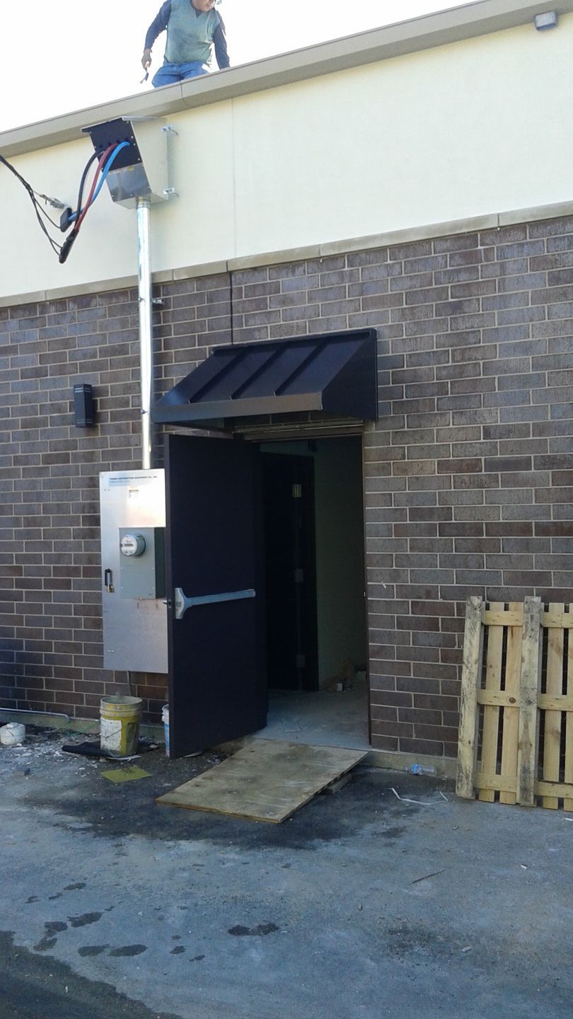 A man is standing on the roof of a brick building.