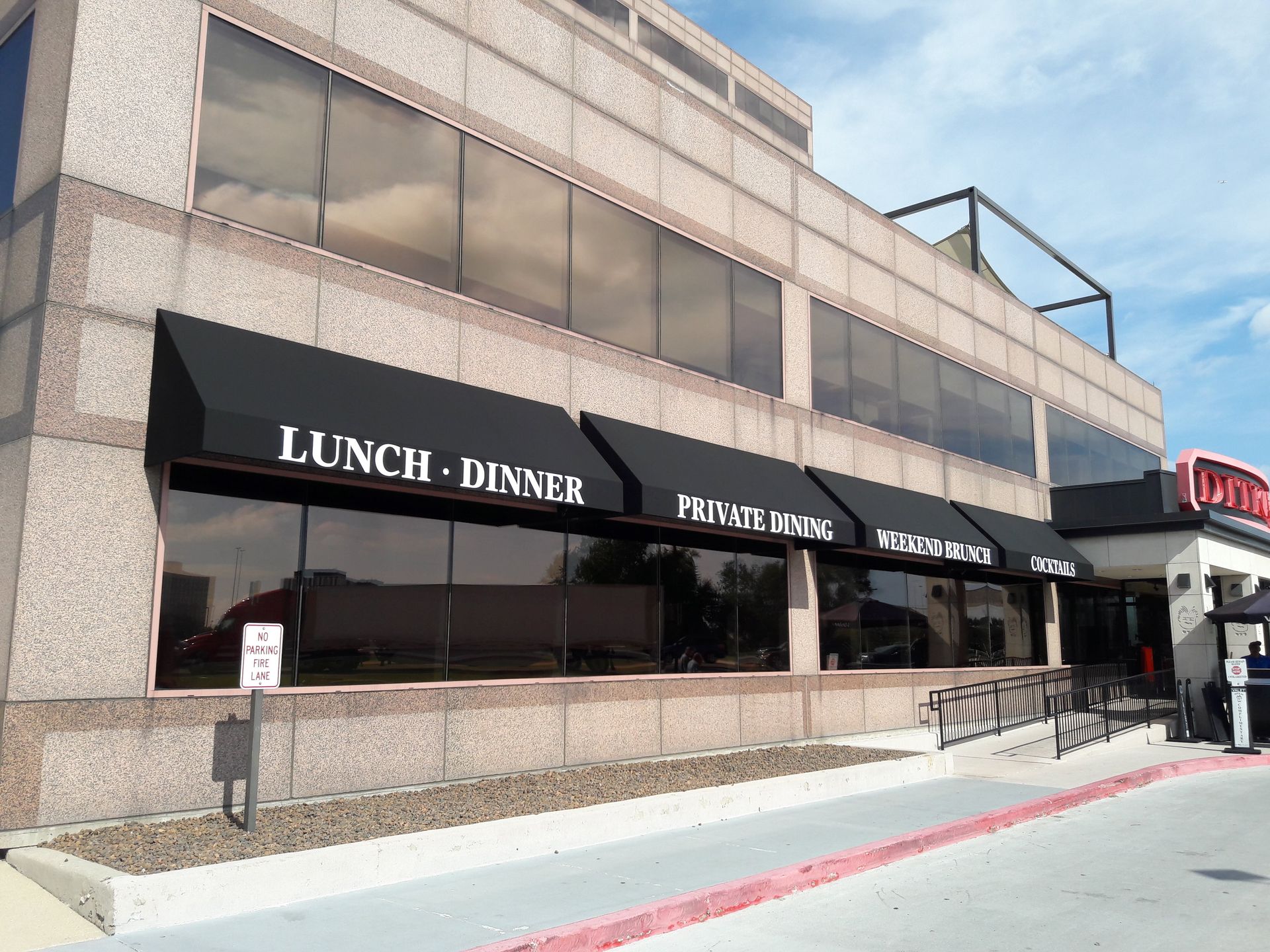 A large building with a black awning that says lunch dinner