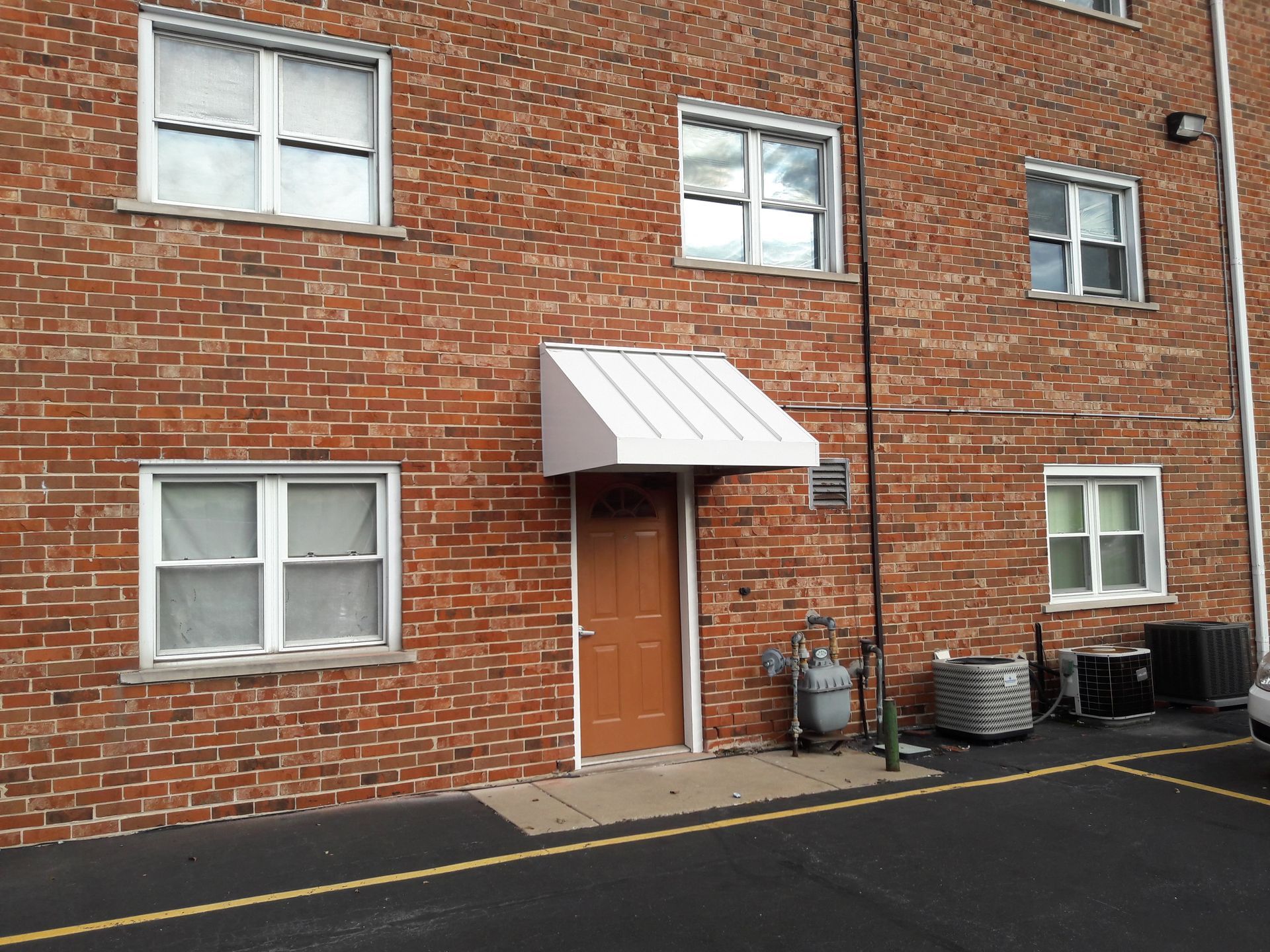 A brick building with a white awning over the door