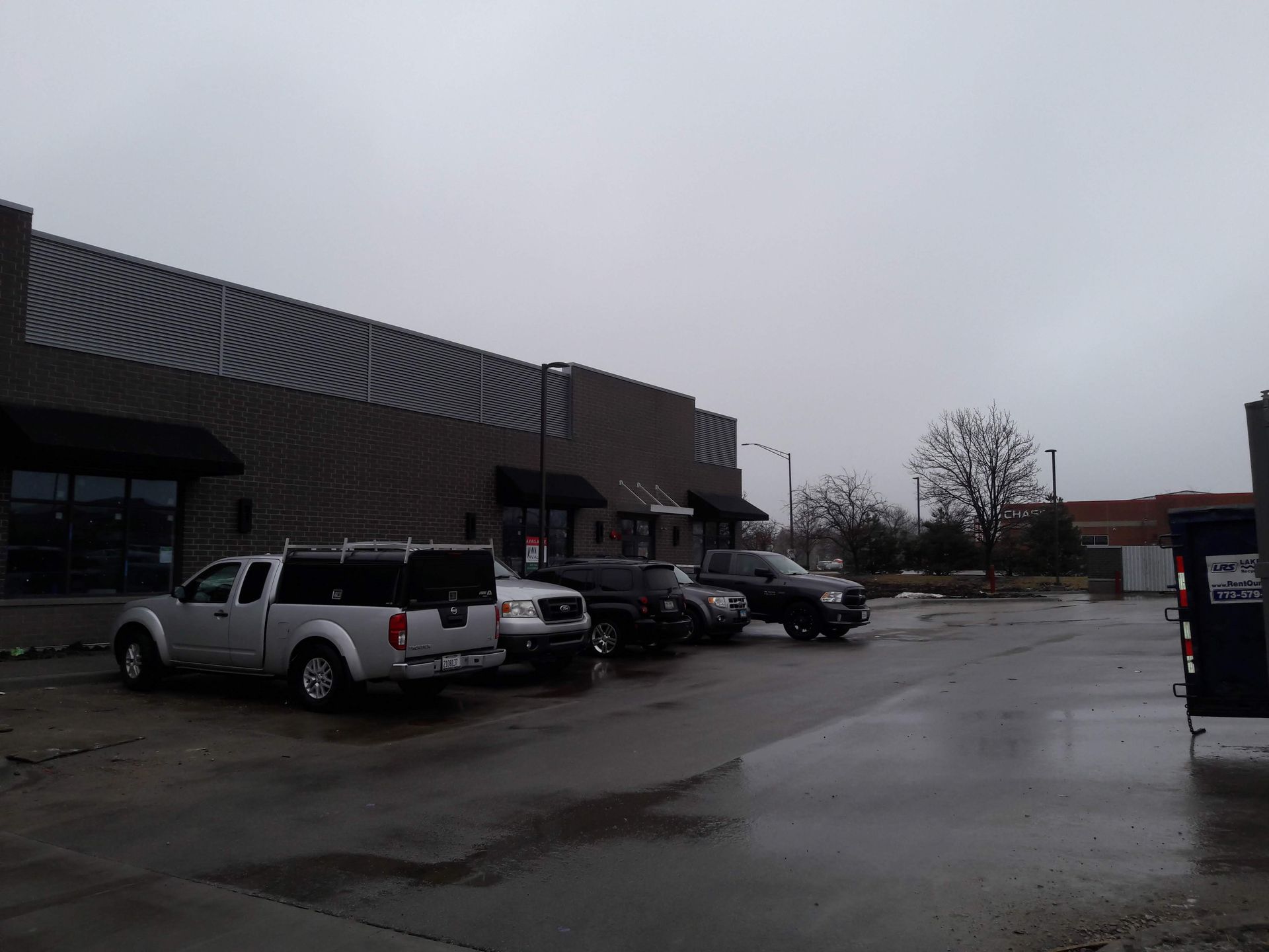 A row of trucks are parked in front of a building