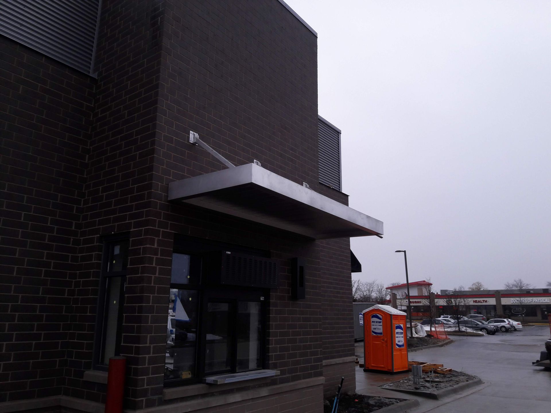 A brick building with a canopy on the side of it
