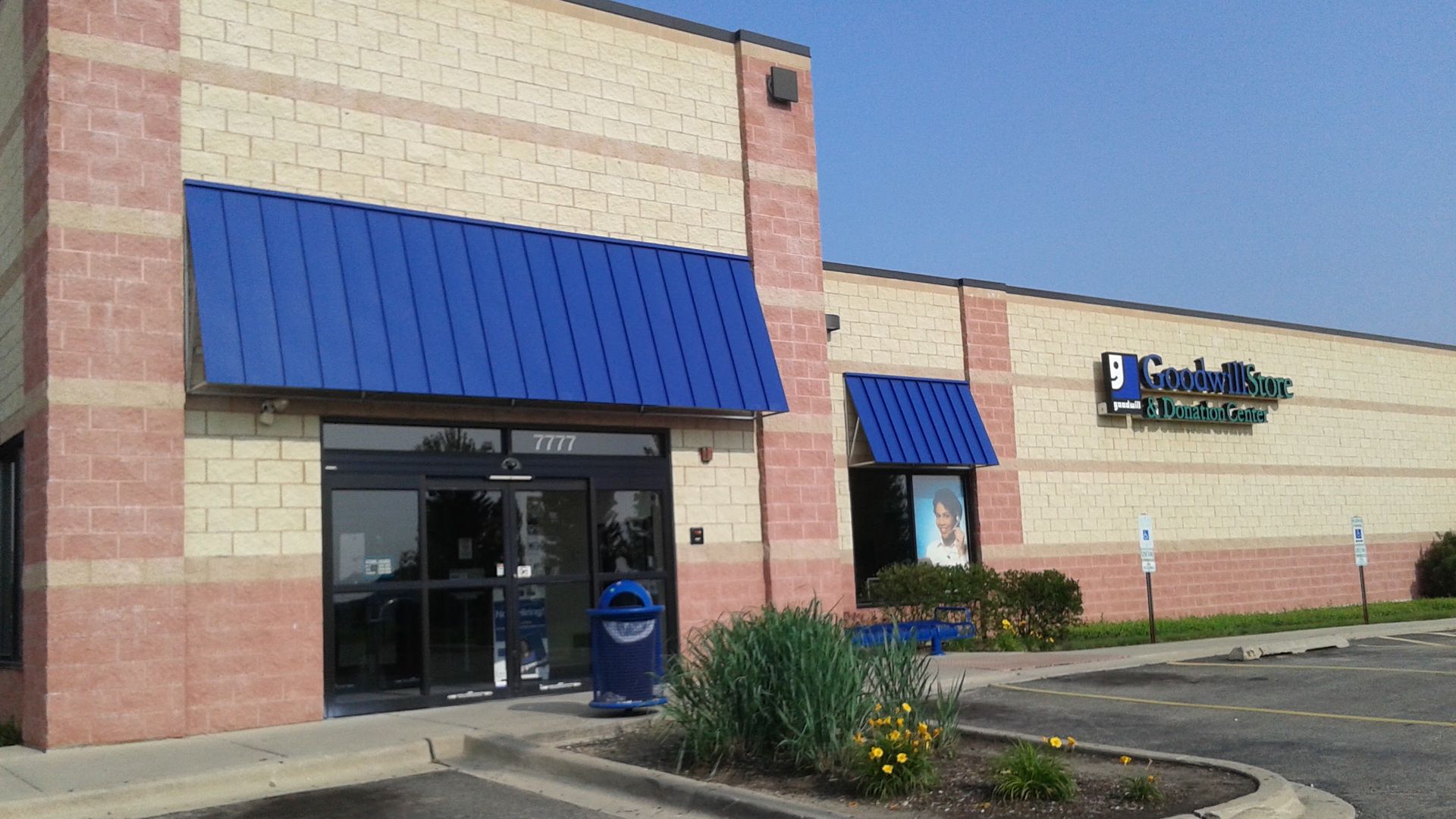 A brick building with a blue awning on the front
