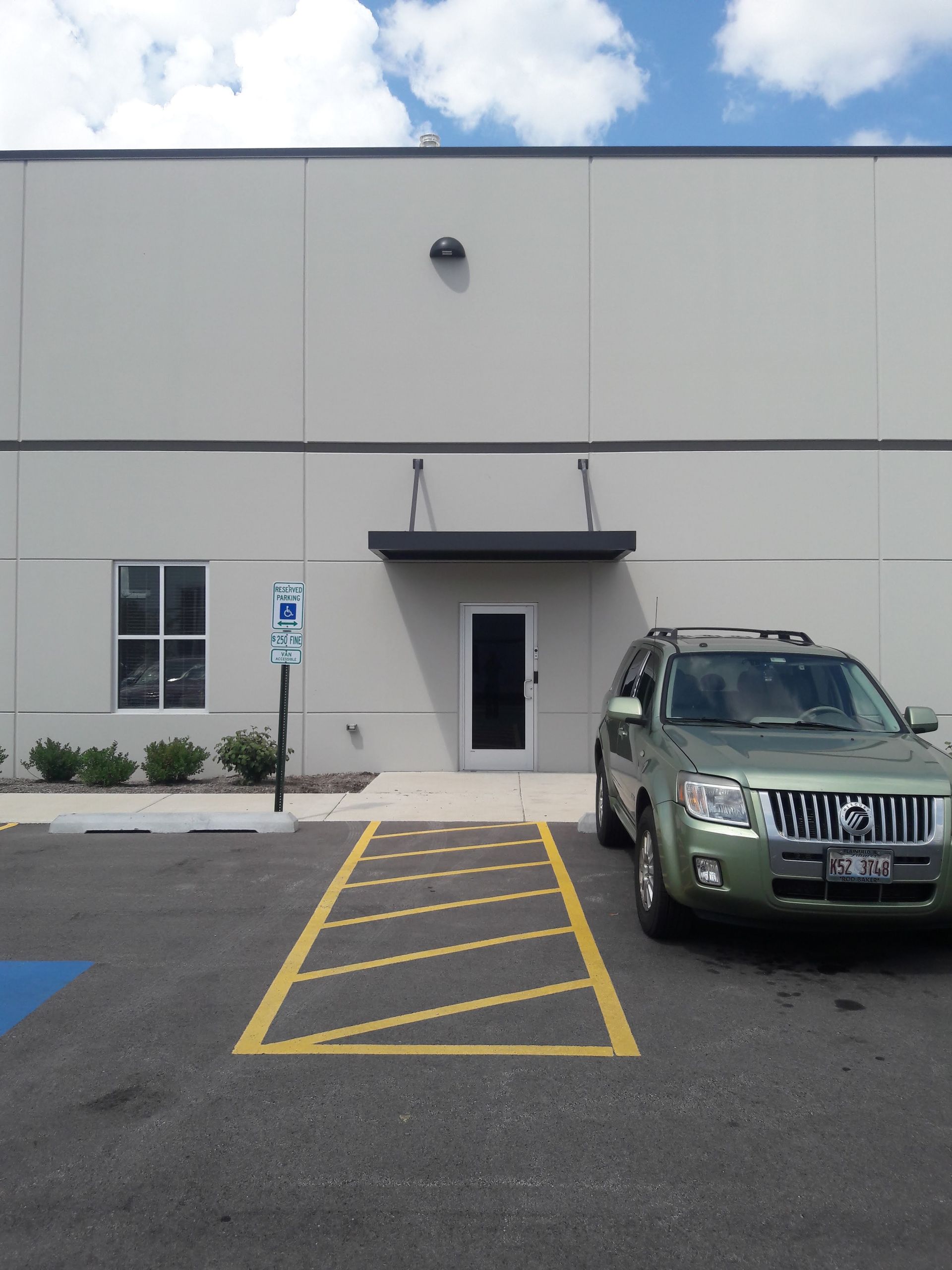 A green suv is parked in front of a building