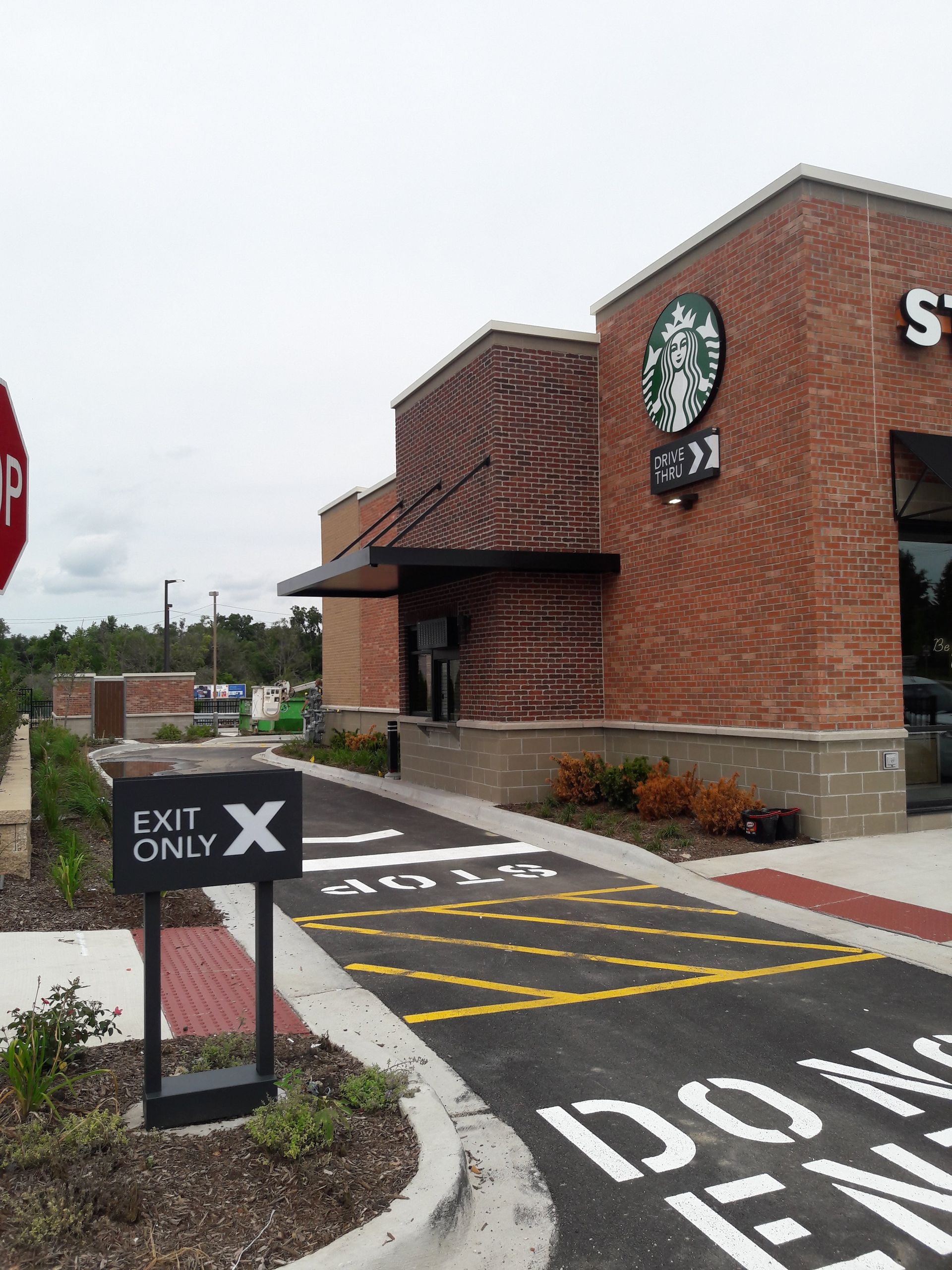 A starbucks restaurant with an exit only sign in front of it
