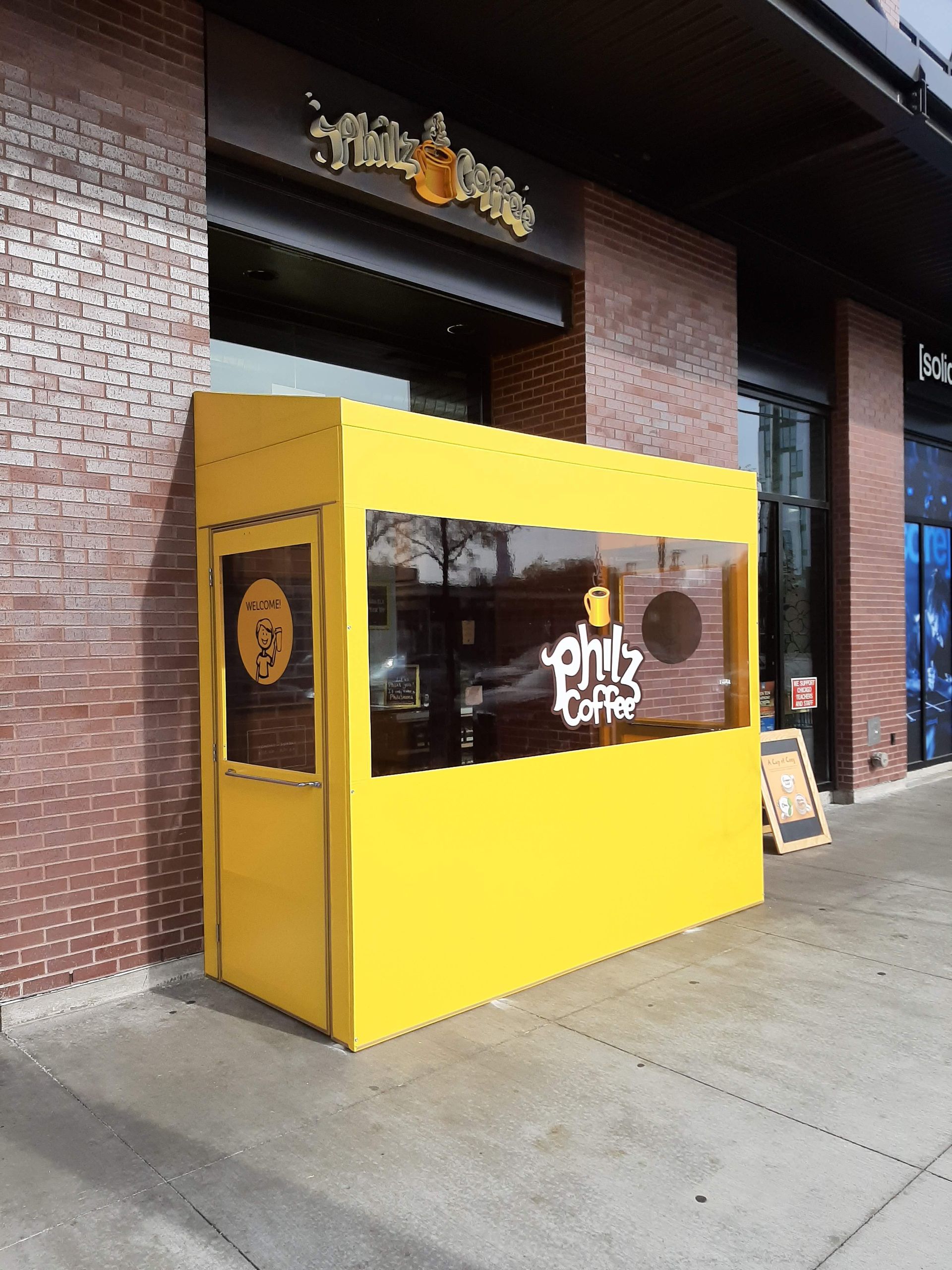 A yellow building with a sign that says pink coffee