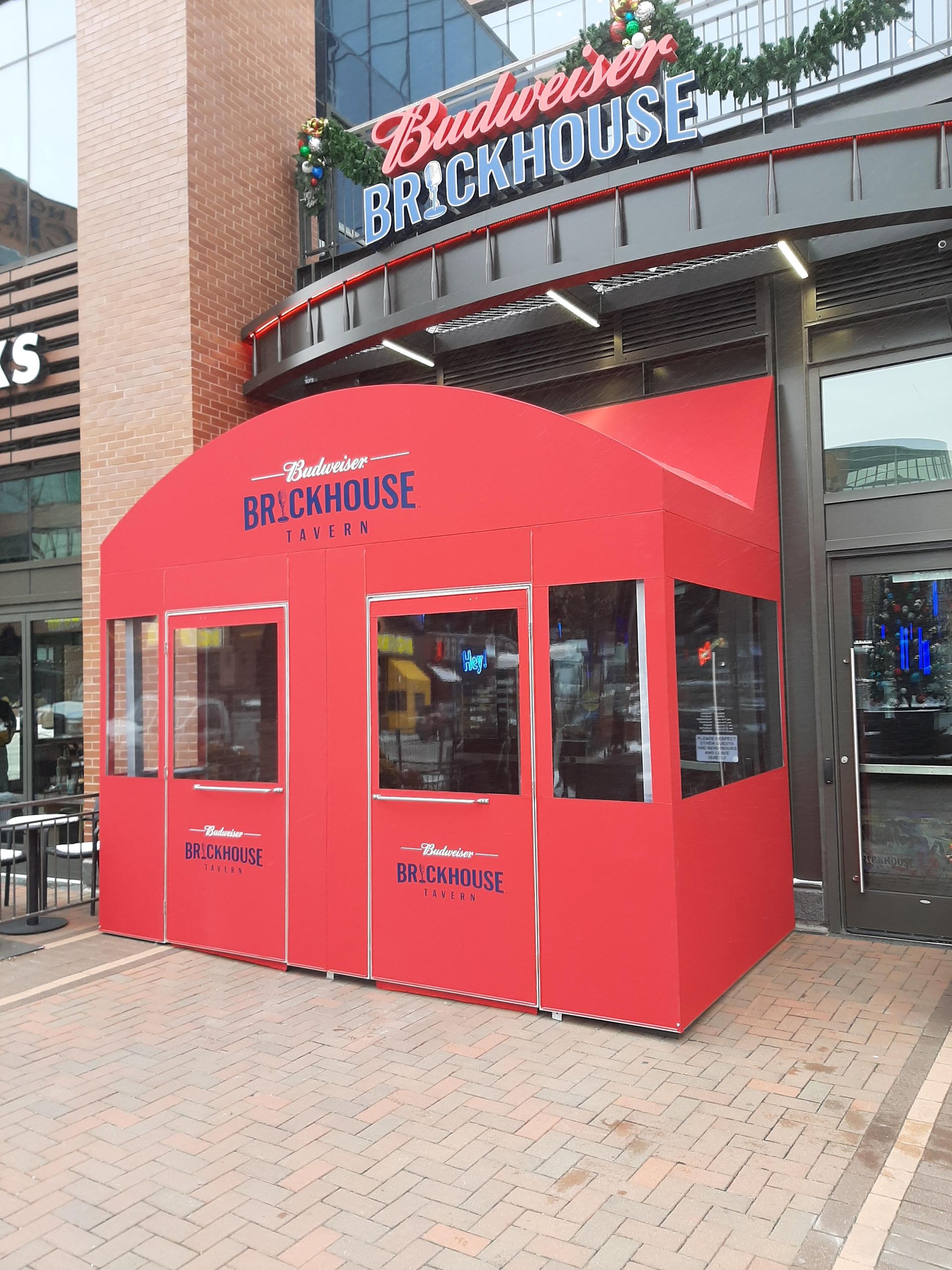 A red tent is in front of a building that says budweiser brickhouse
