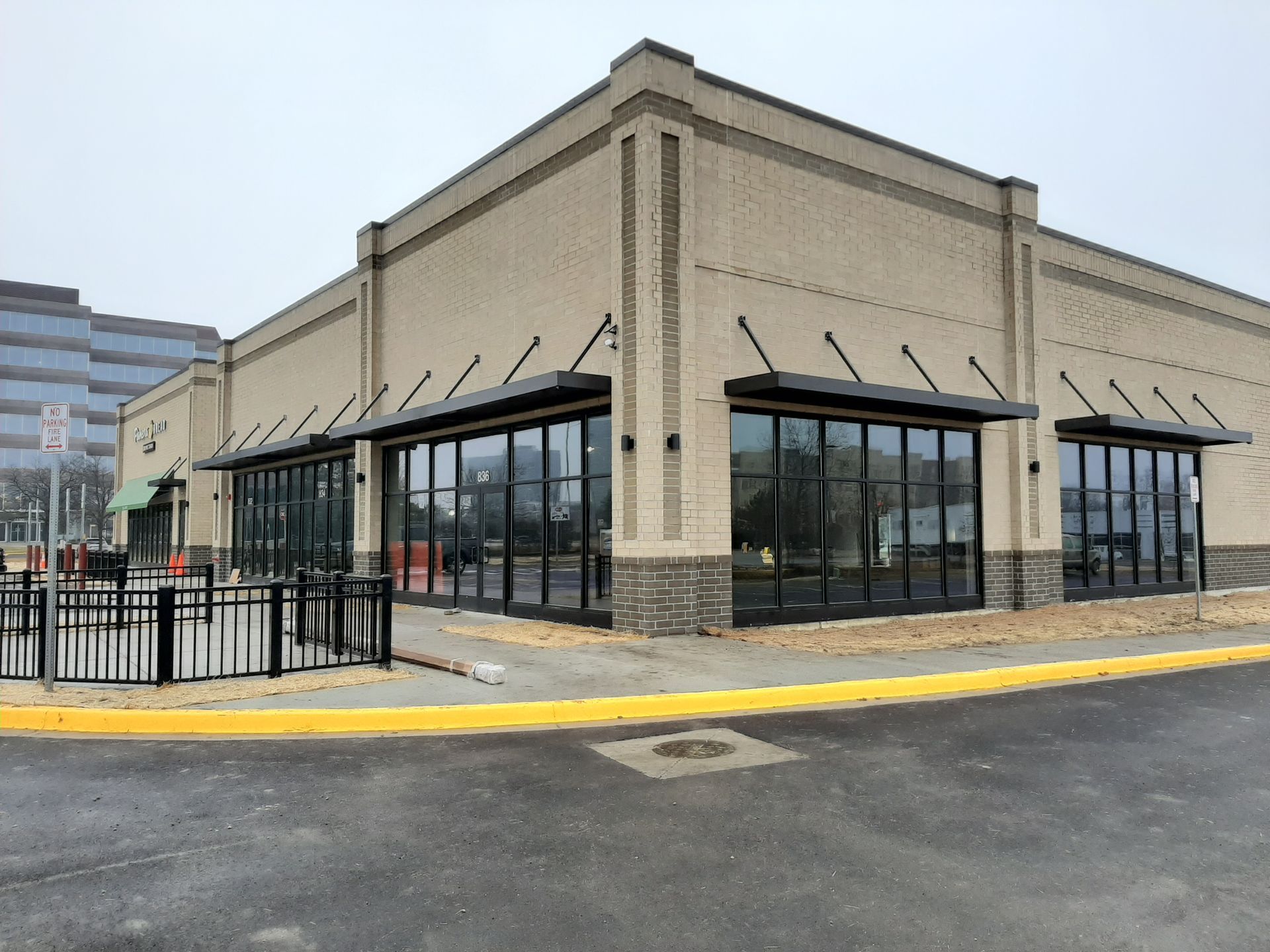 A large brick building with a lot of windows and a yellow curb.