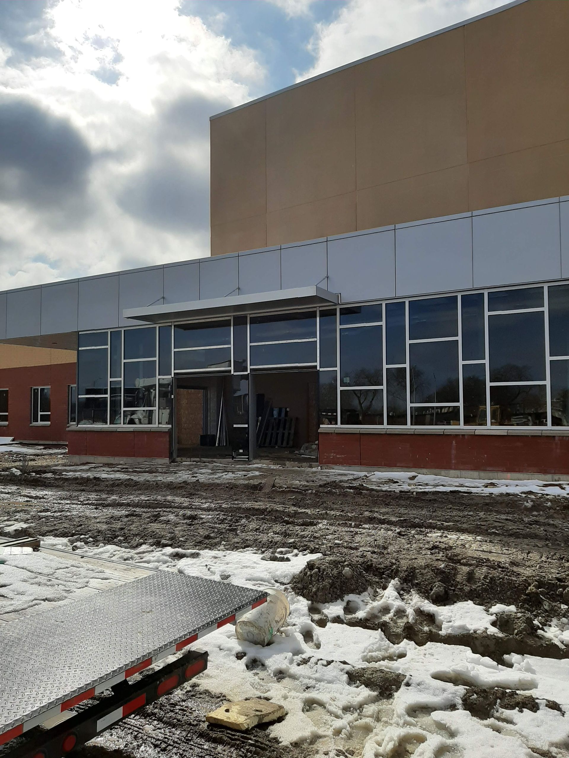 A large building with a lot of windows is being built in the snow.
