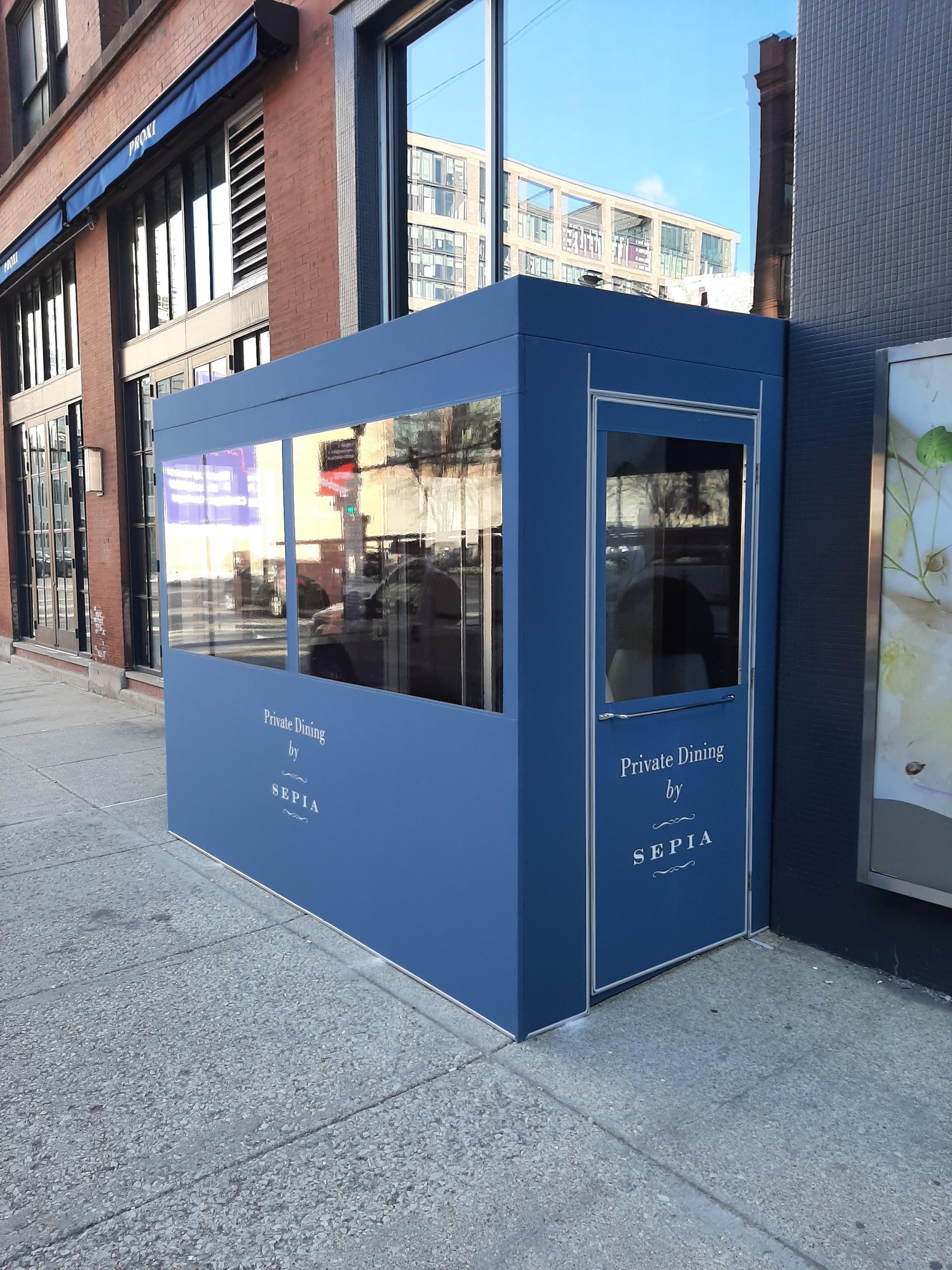 A small blue building with a door and a window