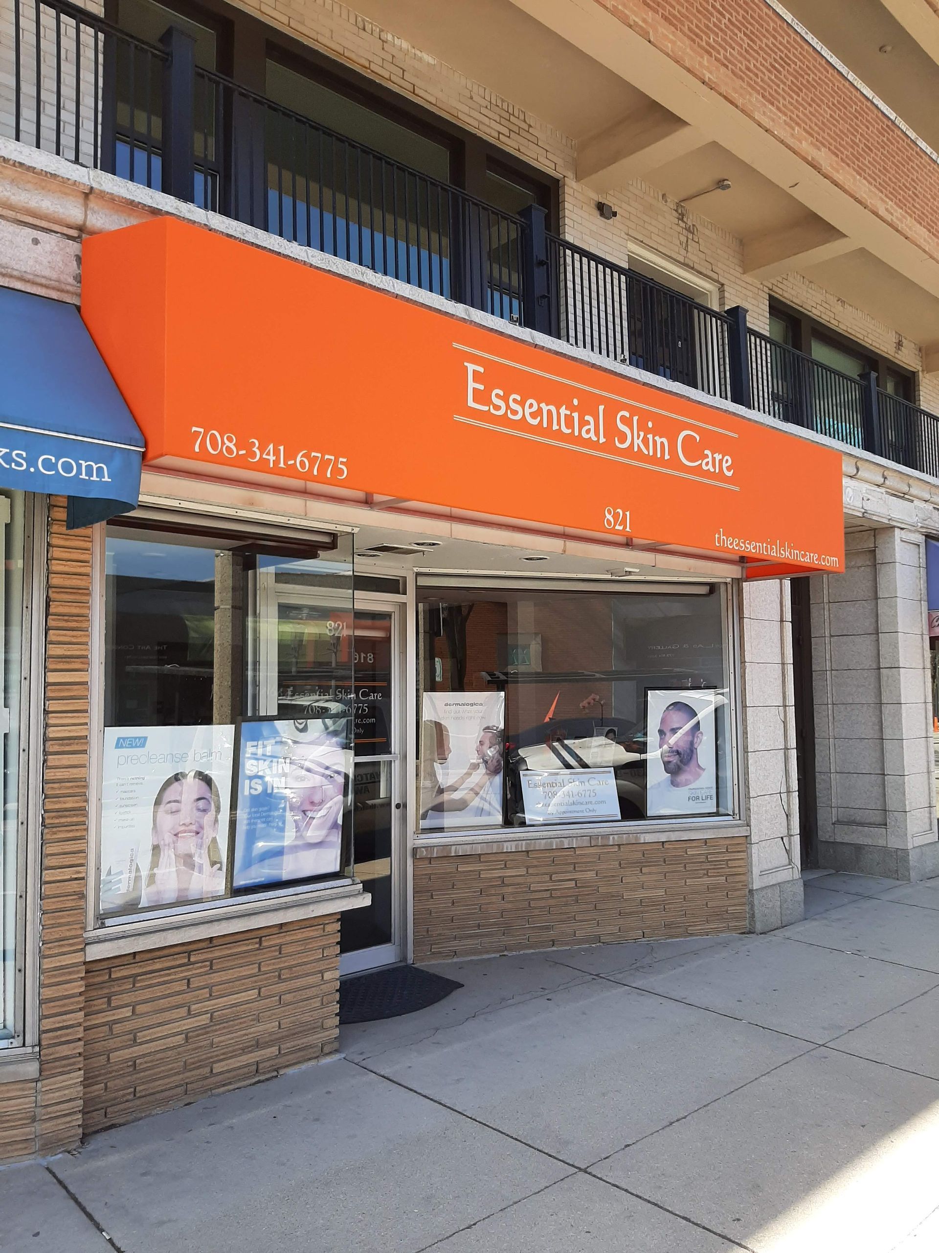 A store front with an orange awning that says essential skin care