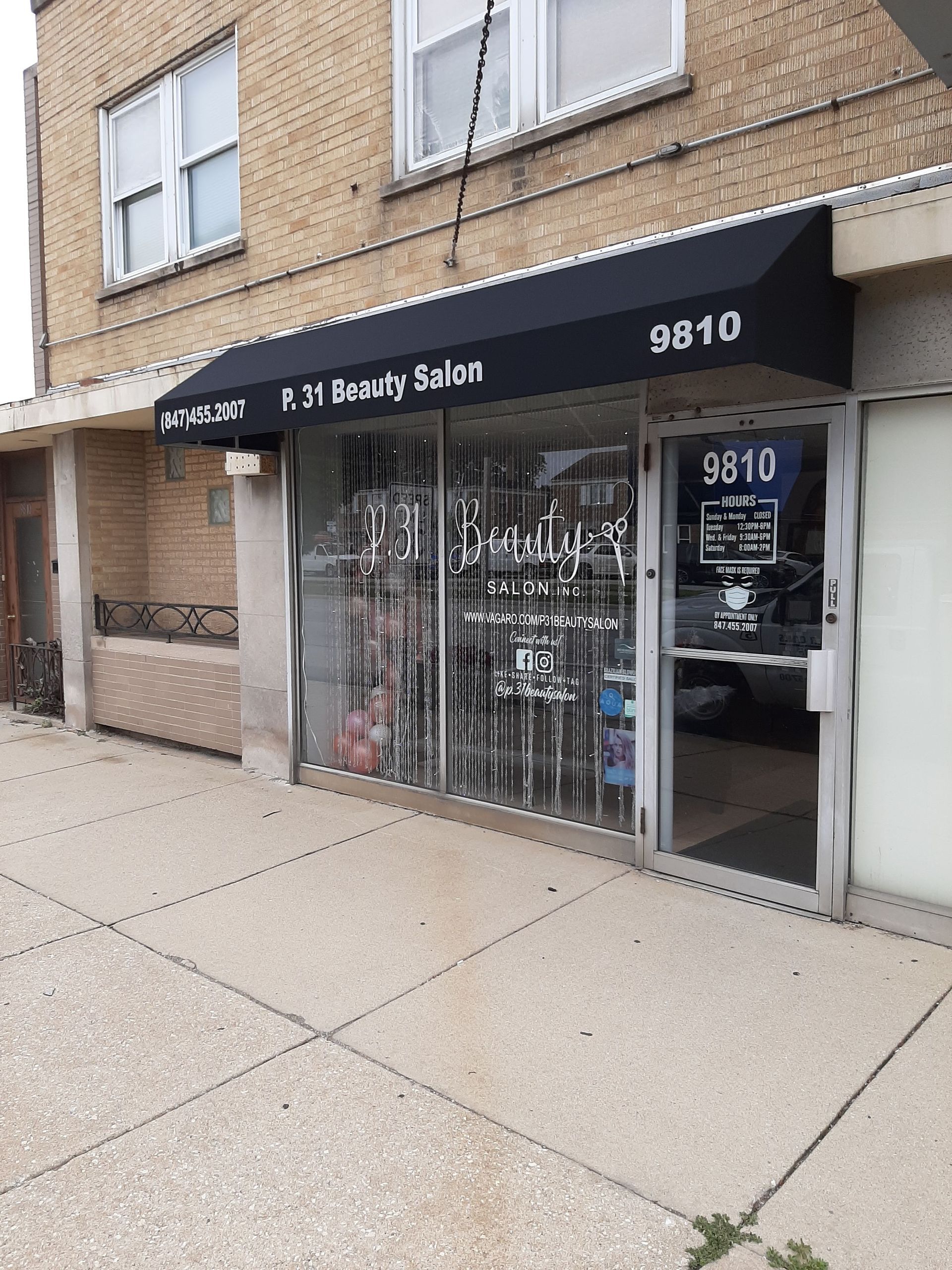 The front of a beauty salon with a black awning