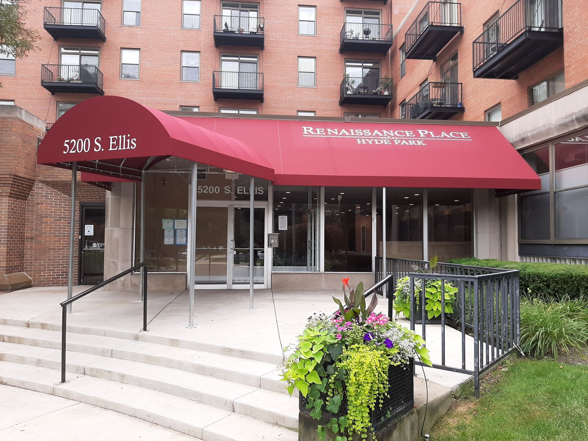 A brick building with a red awning over the entrance