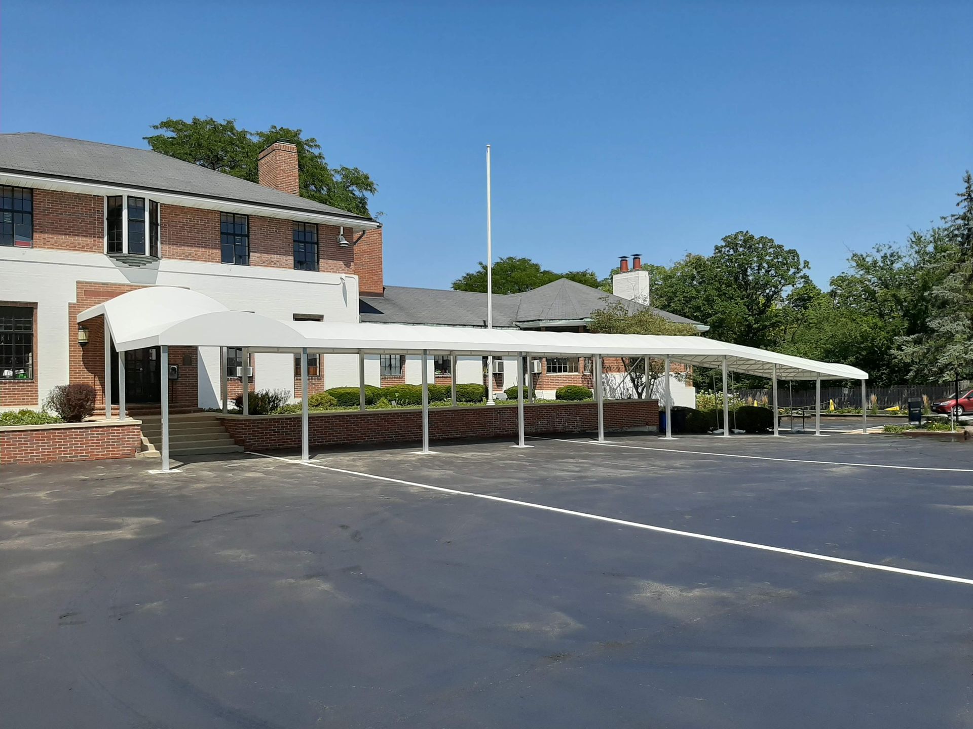 A large white canopy is in front of a brick building