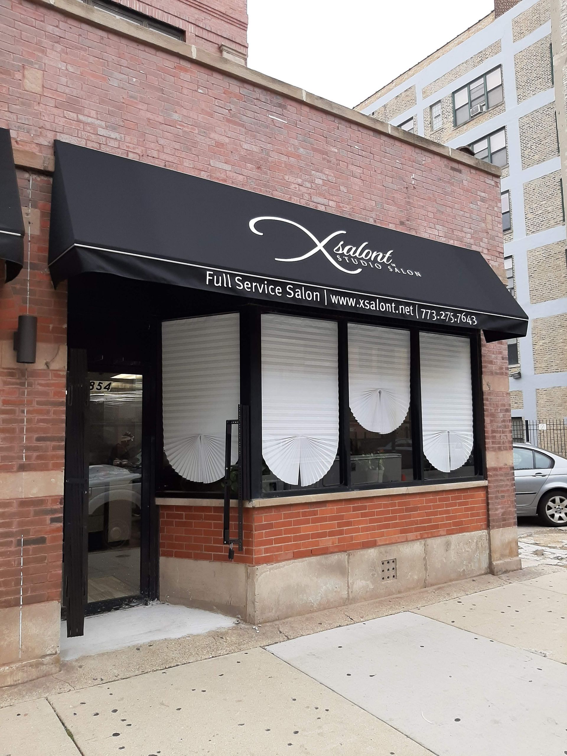 A brick building with a black awning over the door