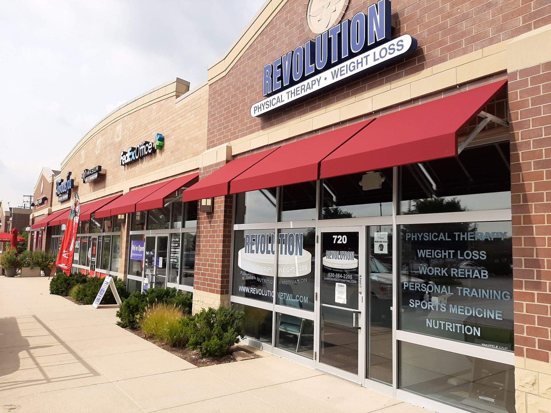 A brick building with a red awning on the front of it.