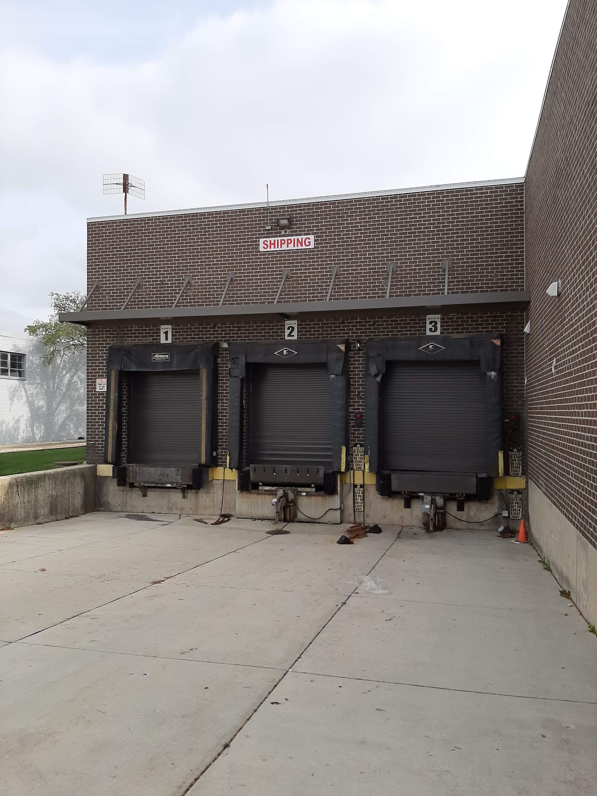 A brick building with three loading docks in front of it