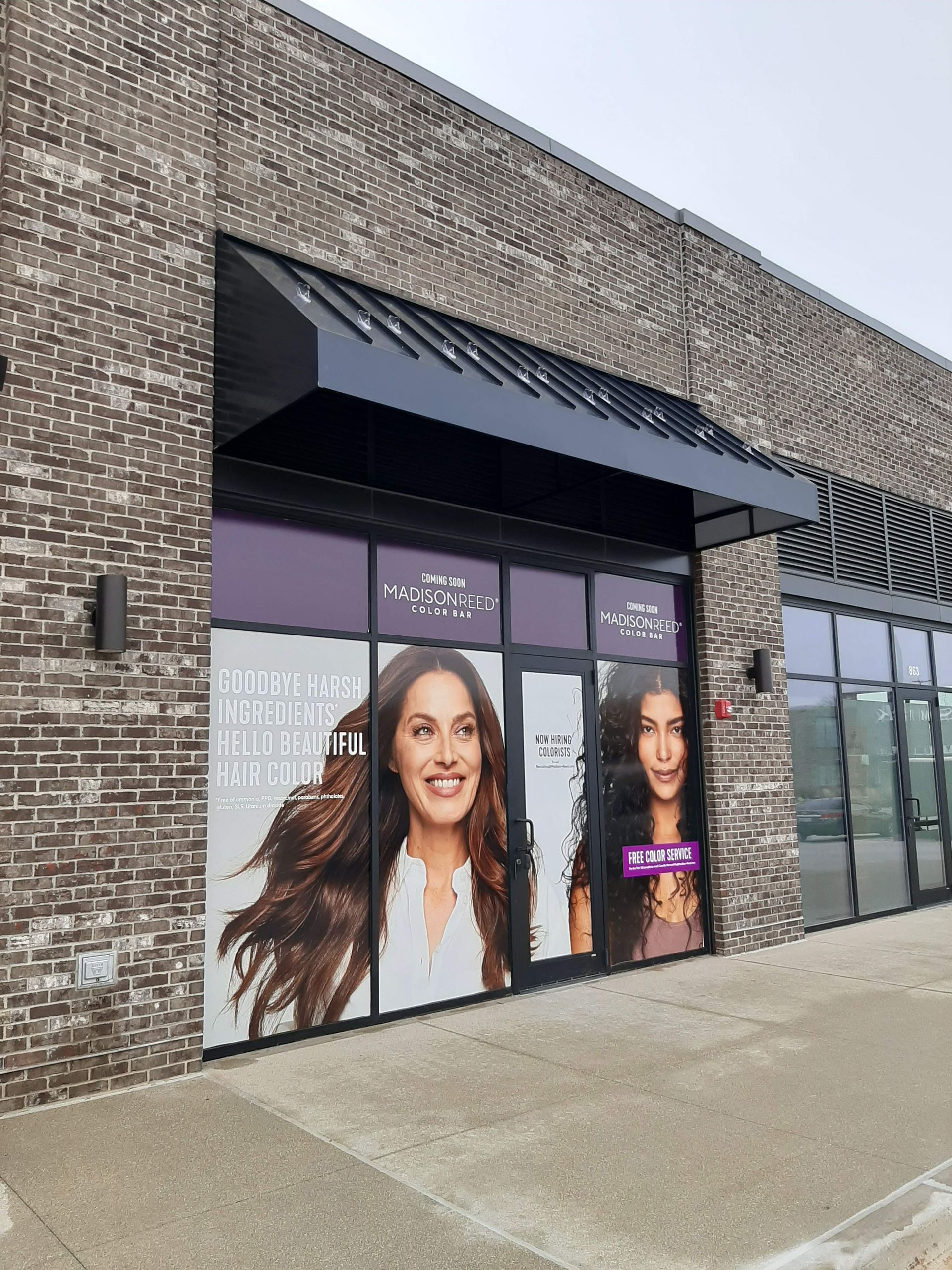 A brick building with a large window with a picture of a woman on it.