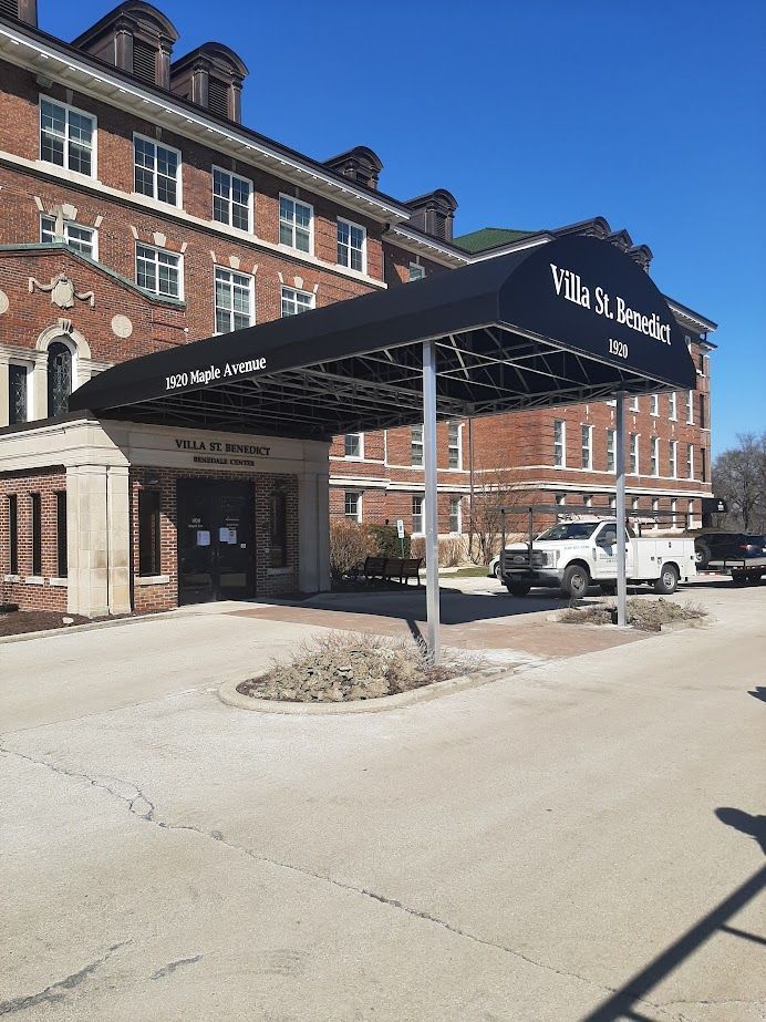 A large brick building with a black awning over the entrance