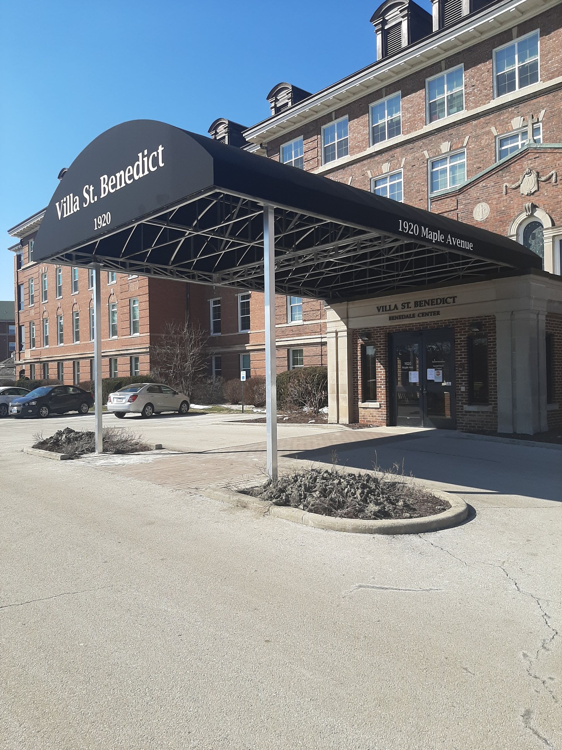 A large brick building with a black awning over the entrance.