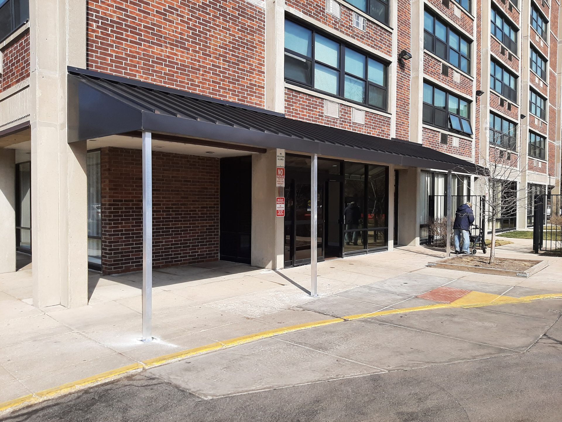 A large brick building with a black awning over the entrance.
