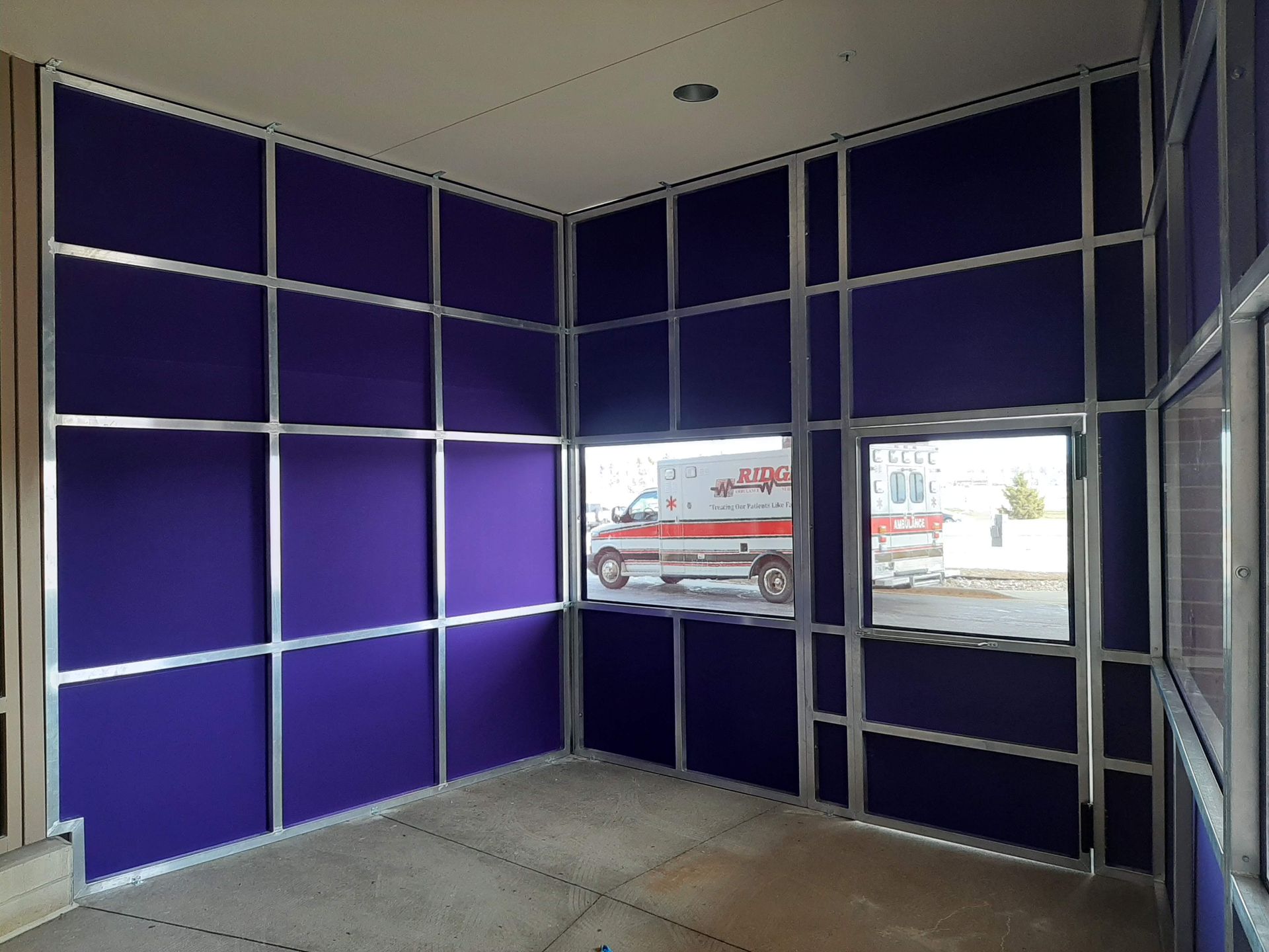 An ambulance is parked in a room with purple walls