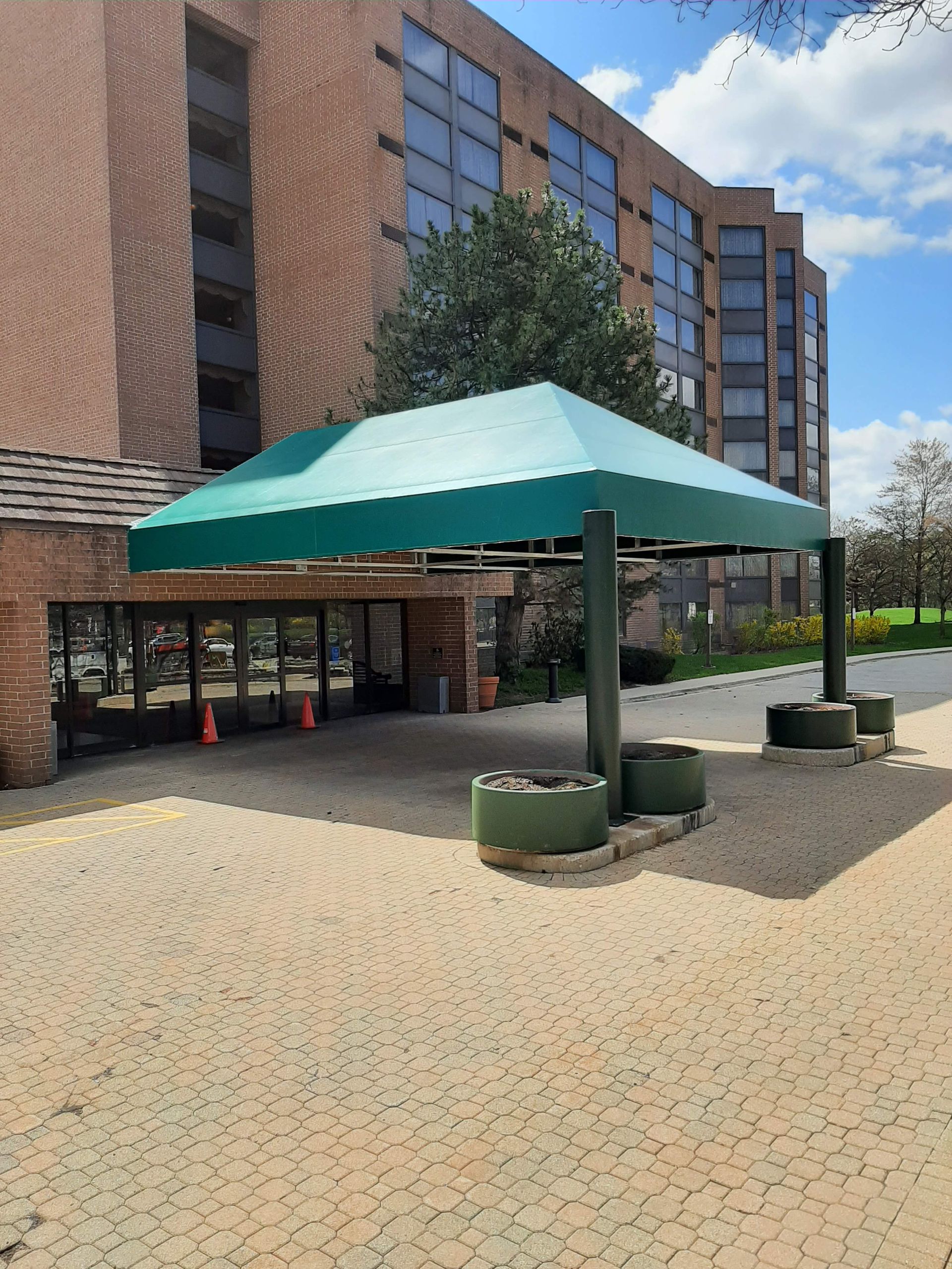 A green canopy is in front of a brick building