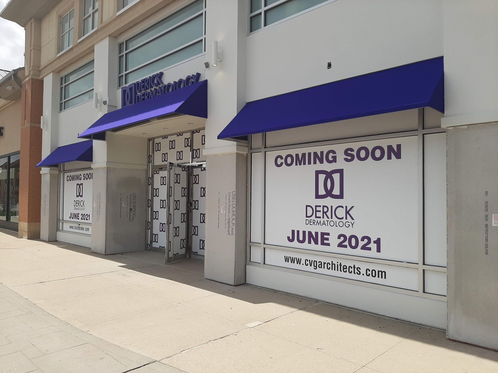 A building with purple awnings and a sign that says coming soon