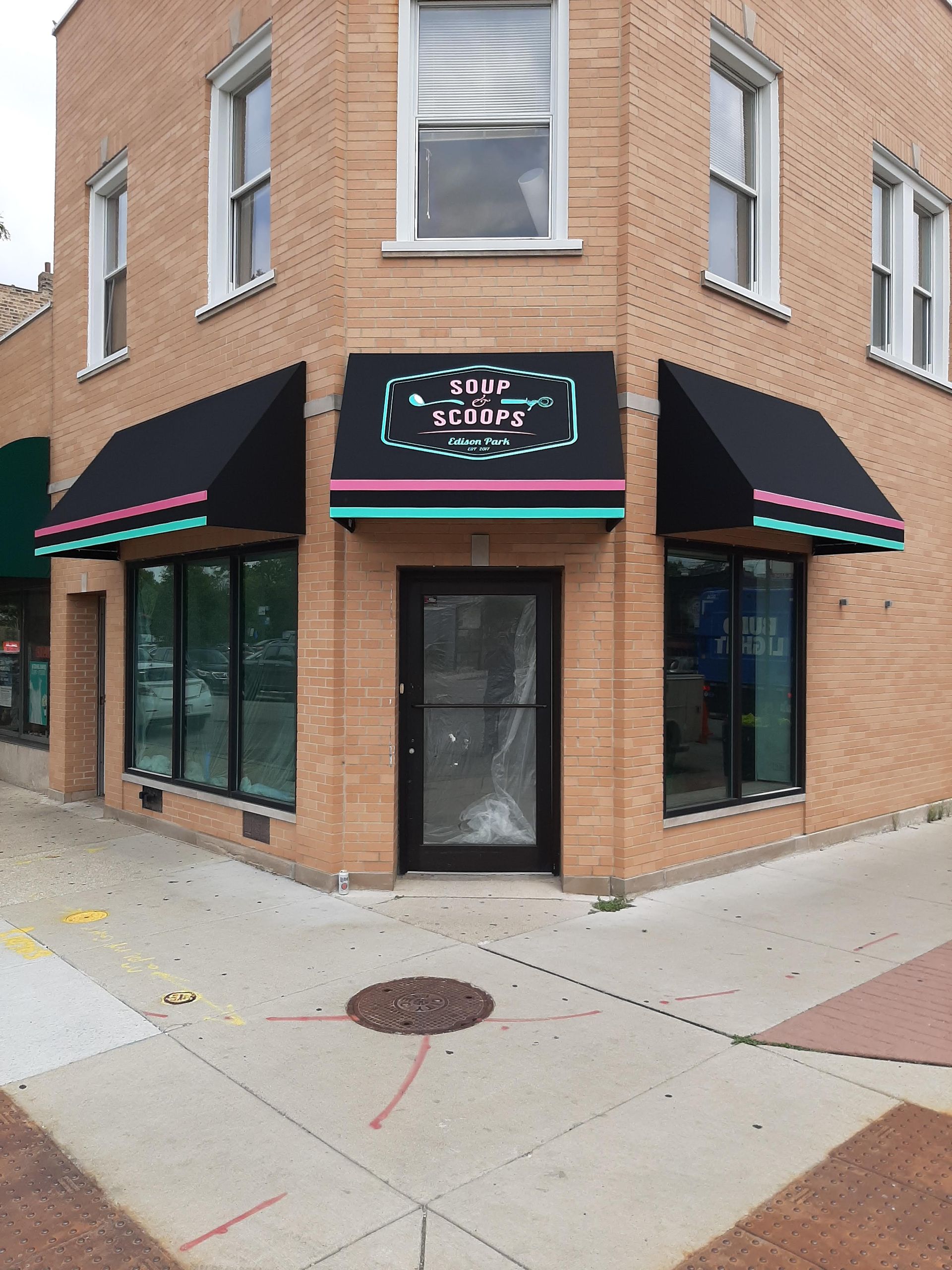 A brick building with a black awning on the corner