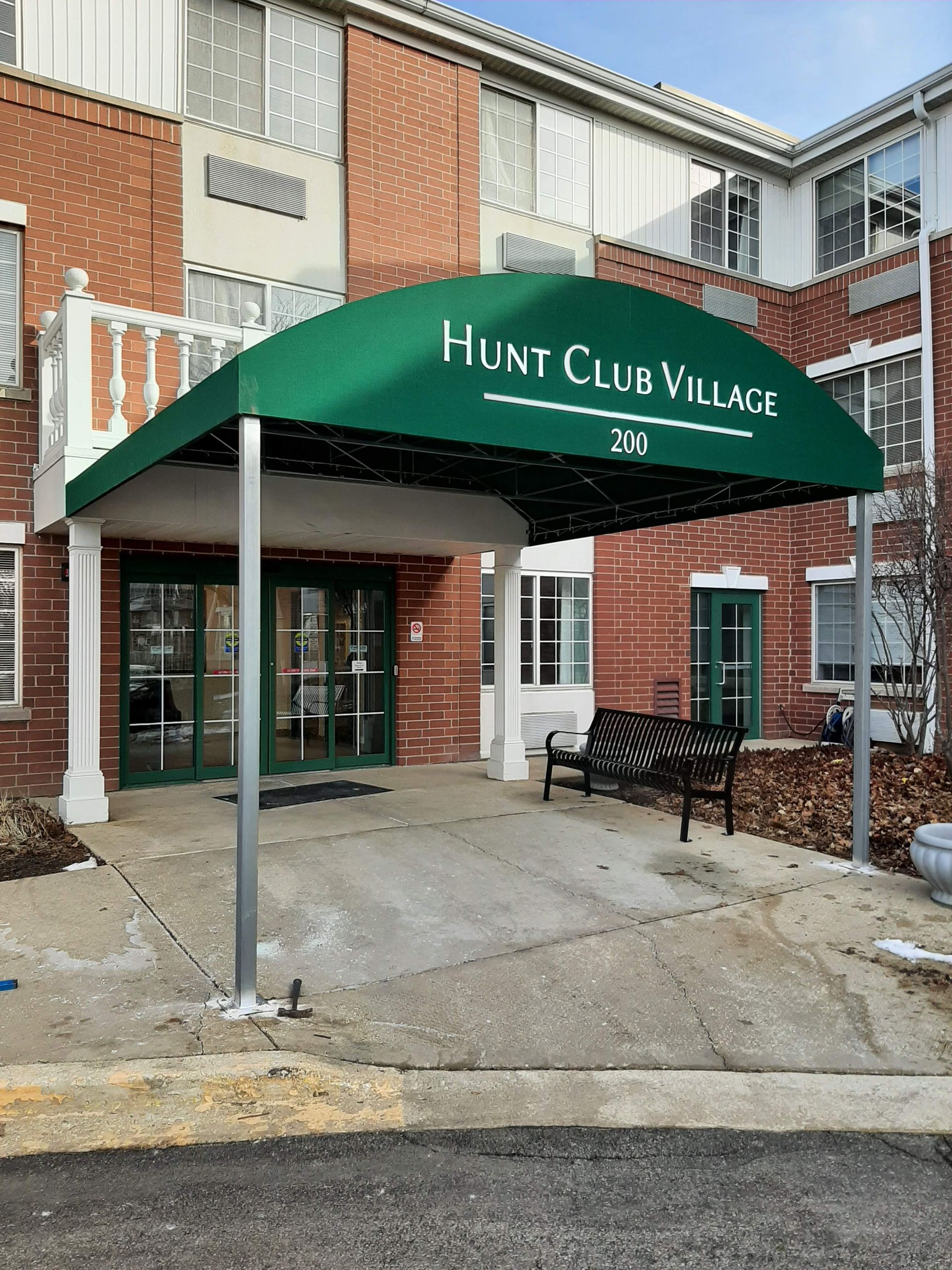 A green canopy over the entrance to hunt club village