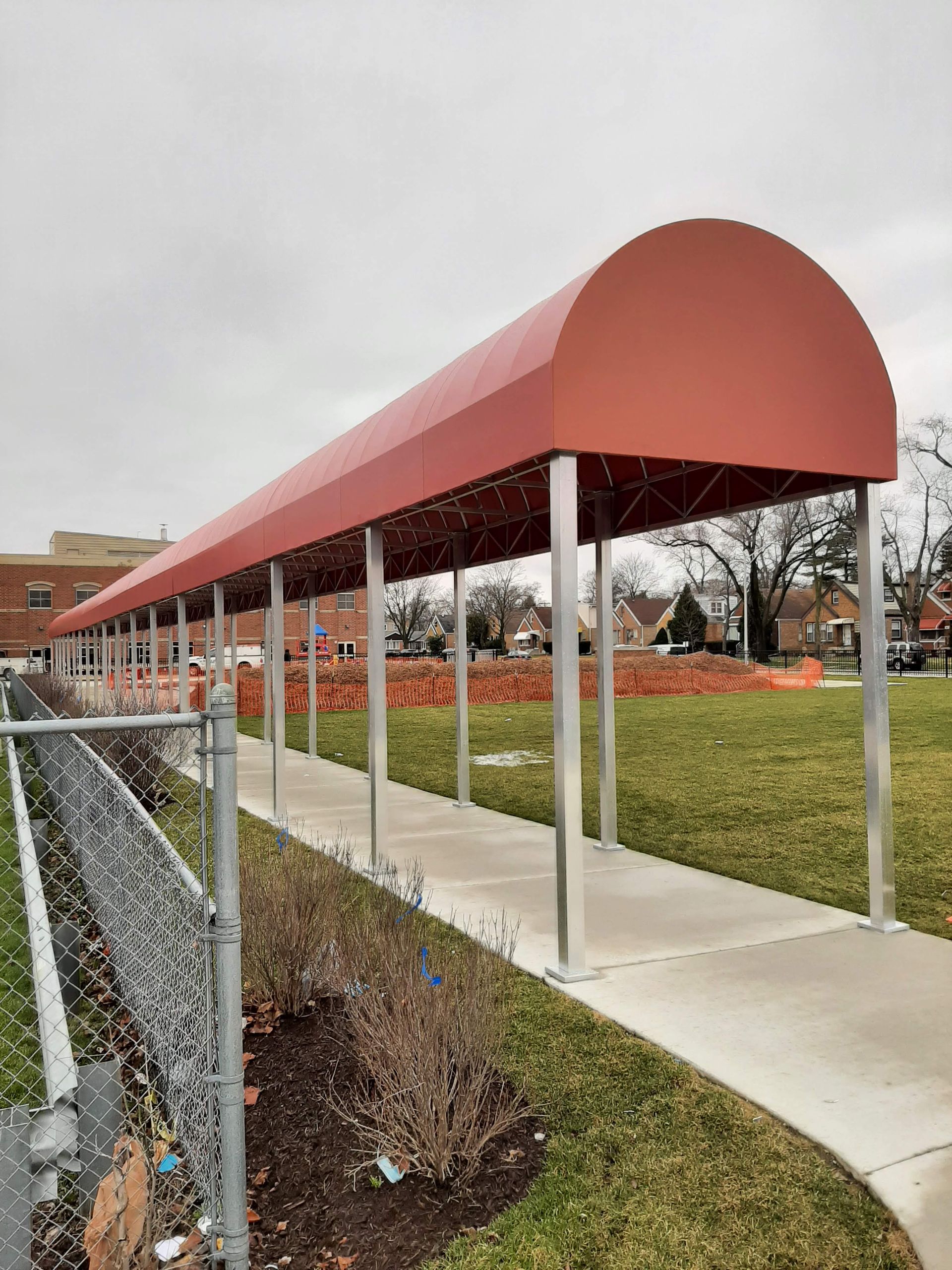 A red awning is covering a walkway in a park.