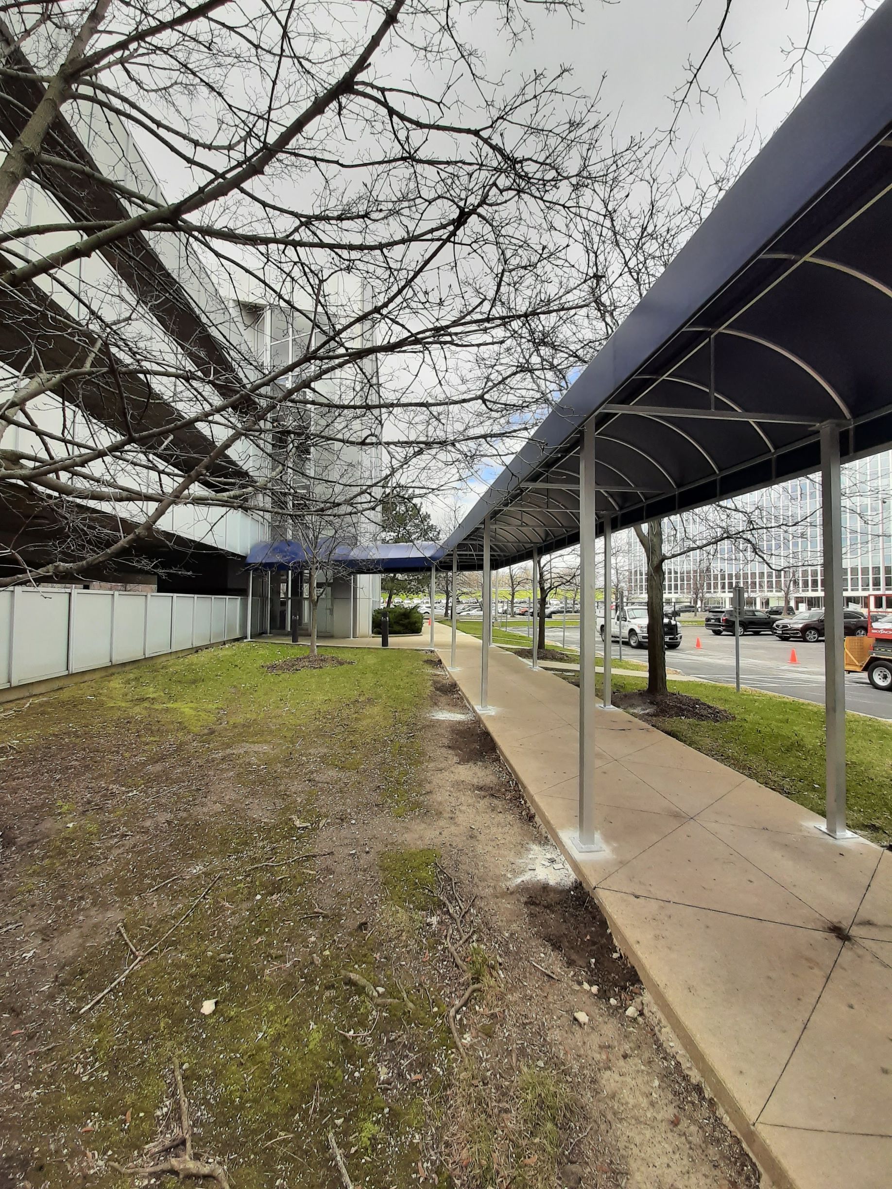 A blue canopy over a sidewalk in front of a building.