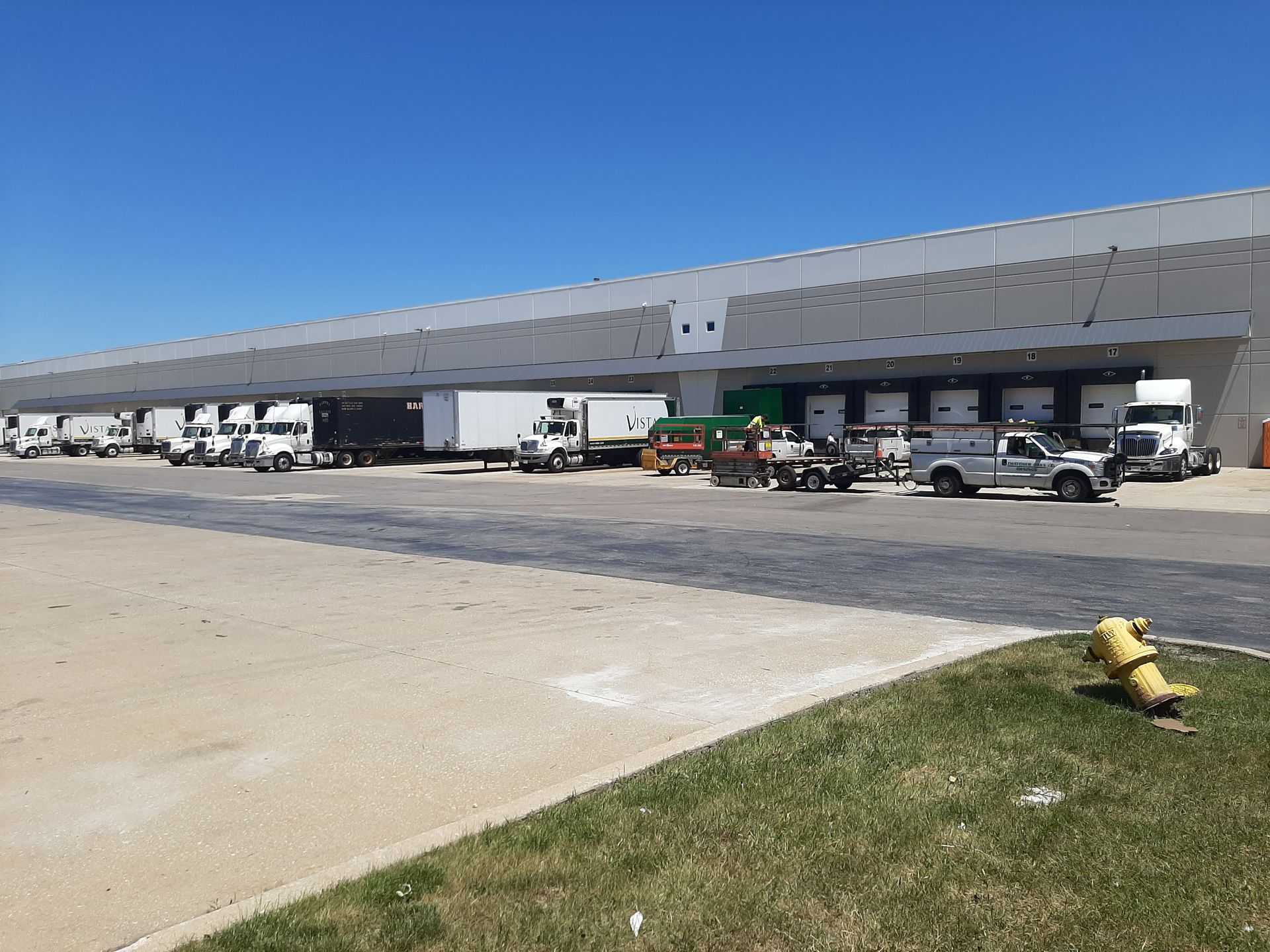 A row of trucks are parked in front of a large building.