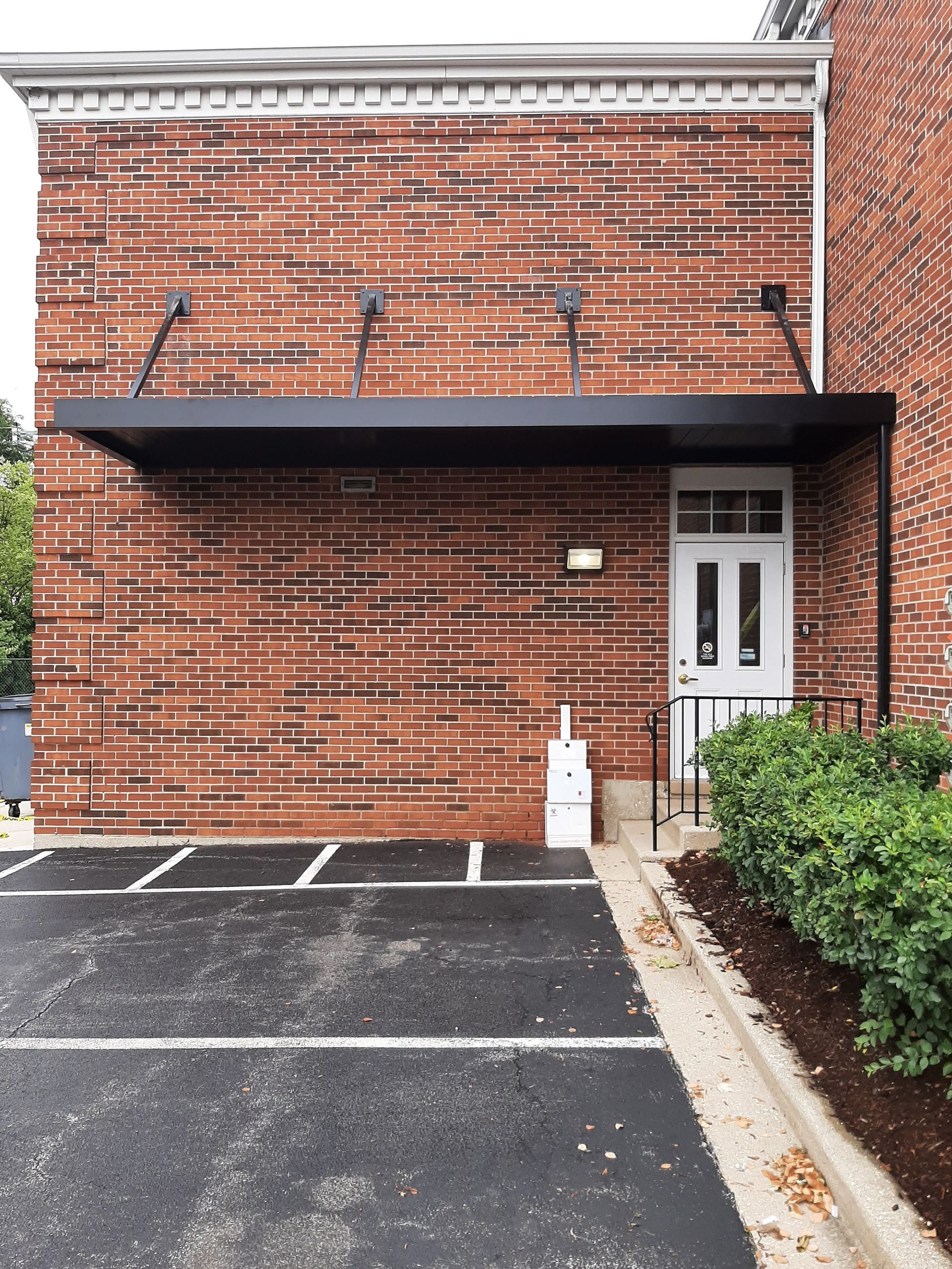 A brick building with a canopy over the front door