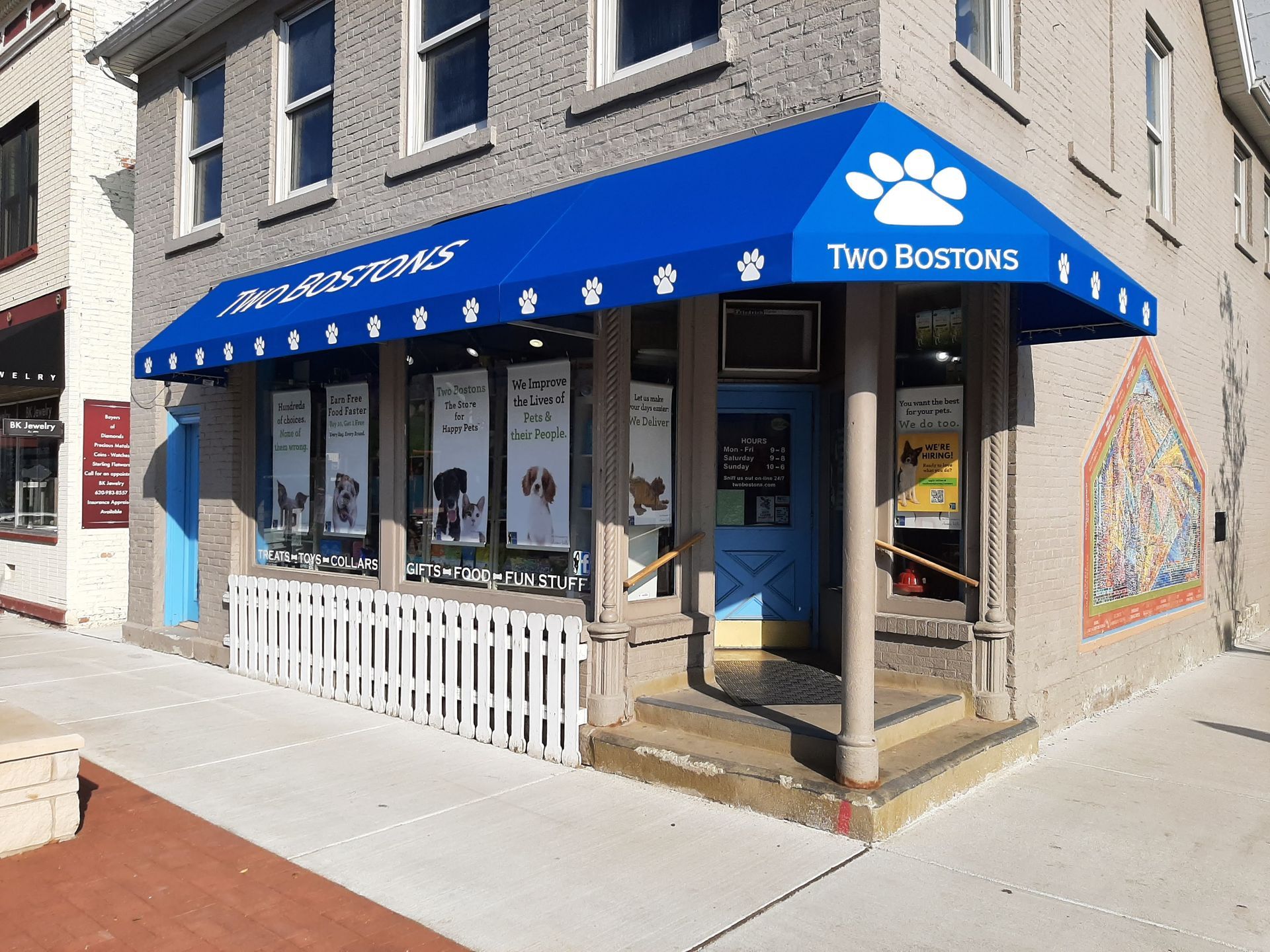 A blue awning with a paw print on it is on the side of a building.