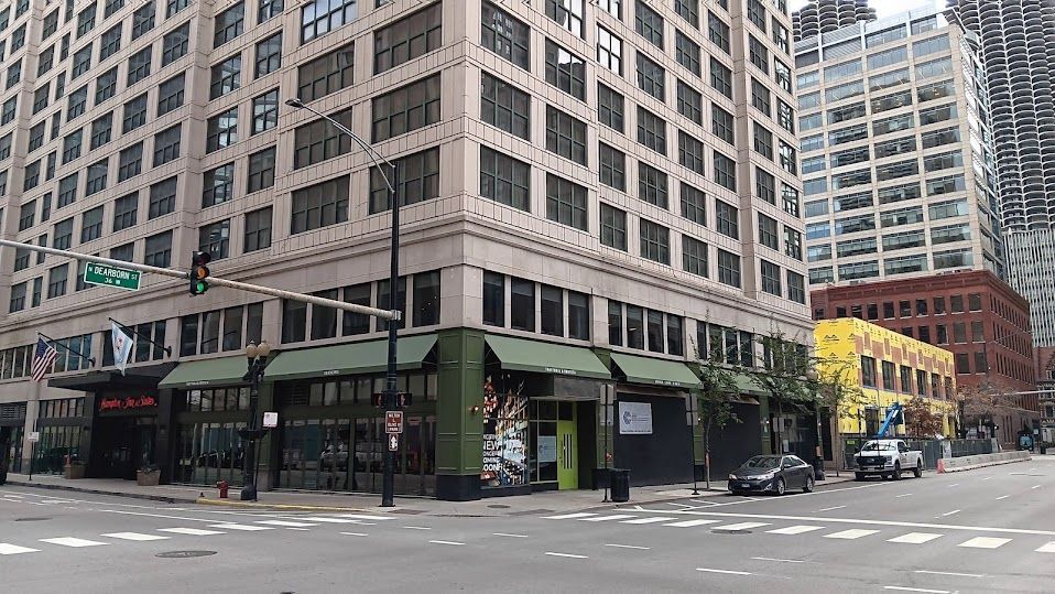 A large building is sitting on the corner of a city street.