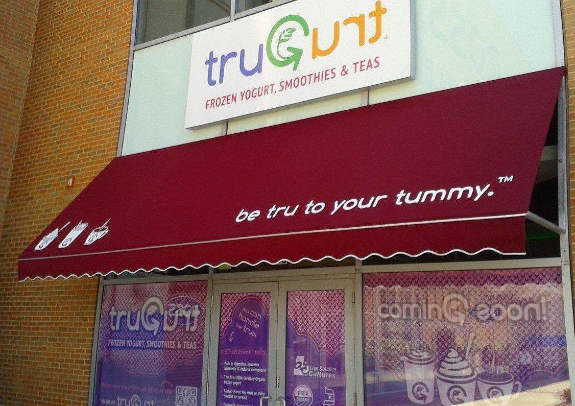 A store front with a red awning that says