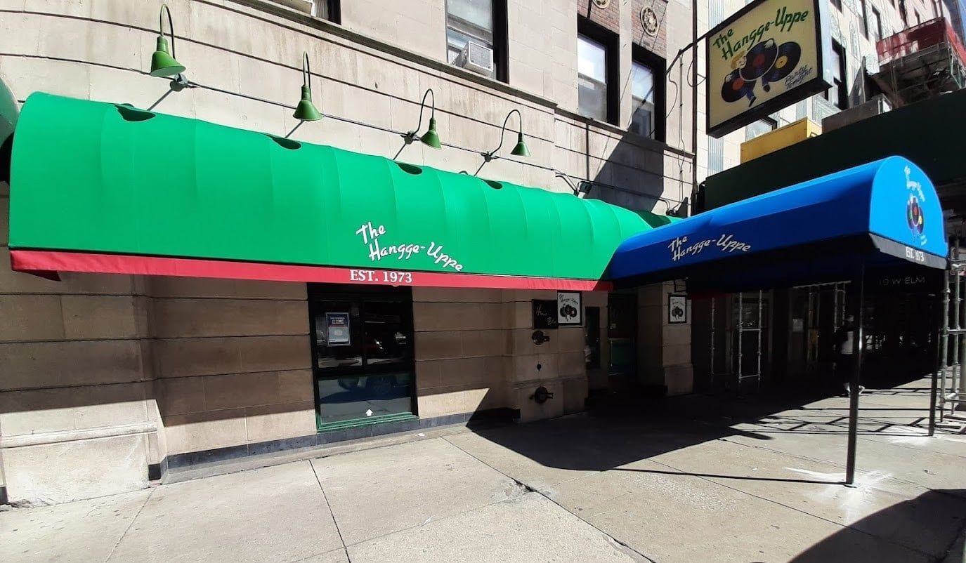 A restaurant with a green awning and a blue awning