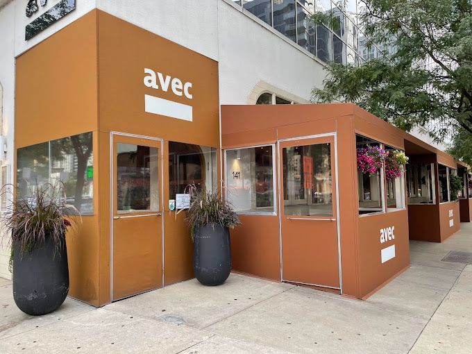 A brown building with a sign that says avec on it