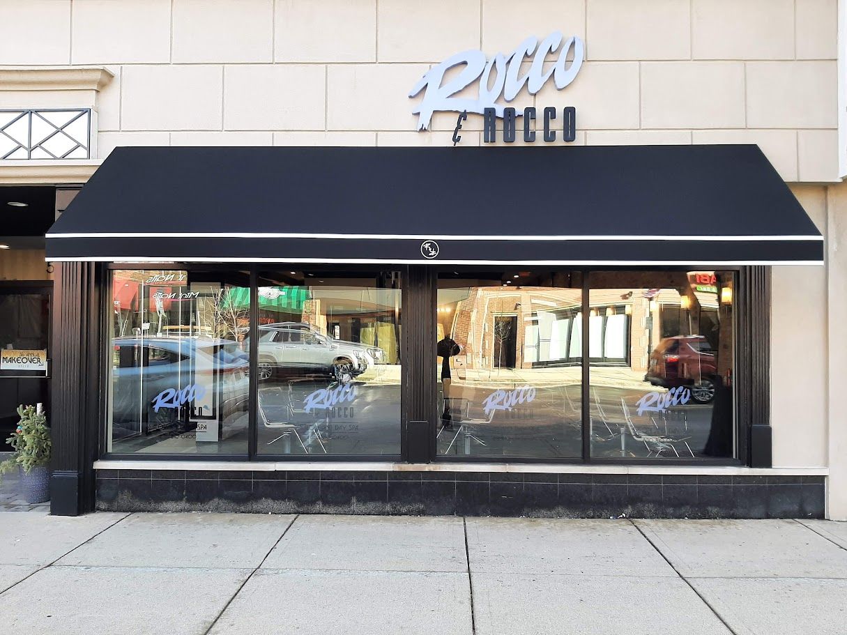 A store front with a black awning over it