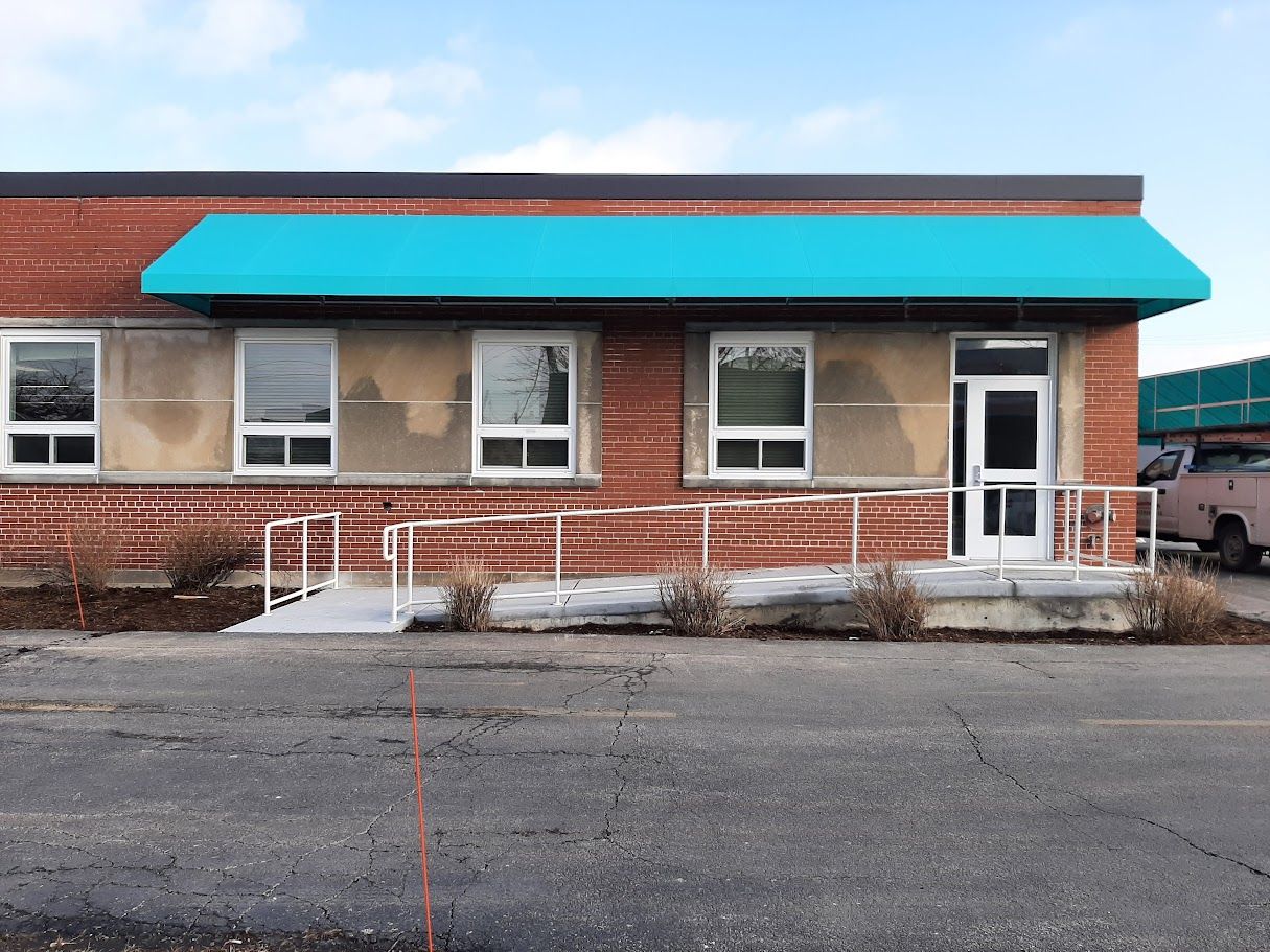 A brick building with a blue awning on top of it