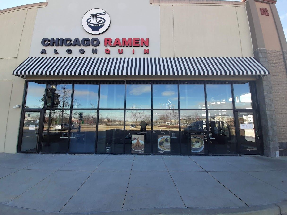 The front of a chicago ramen restaurant with a striped awning