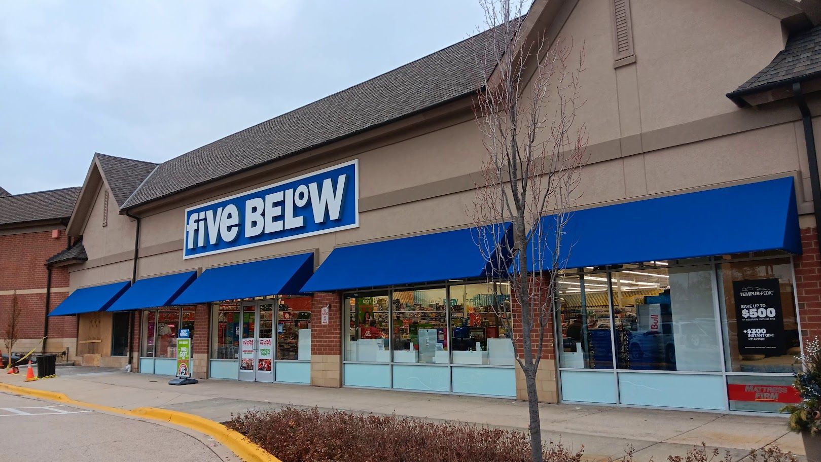 The outside of a five below store with blue awnings