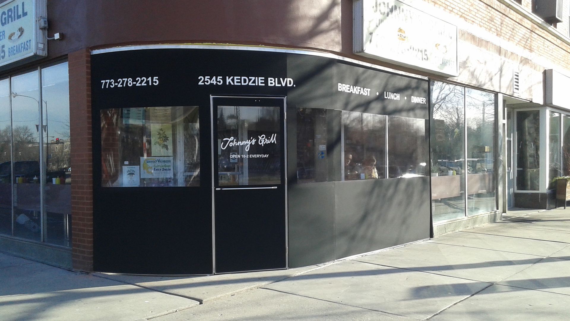 A brick building with a black awning on the side of it
