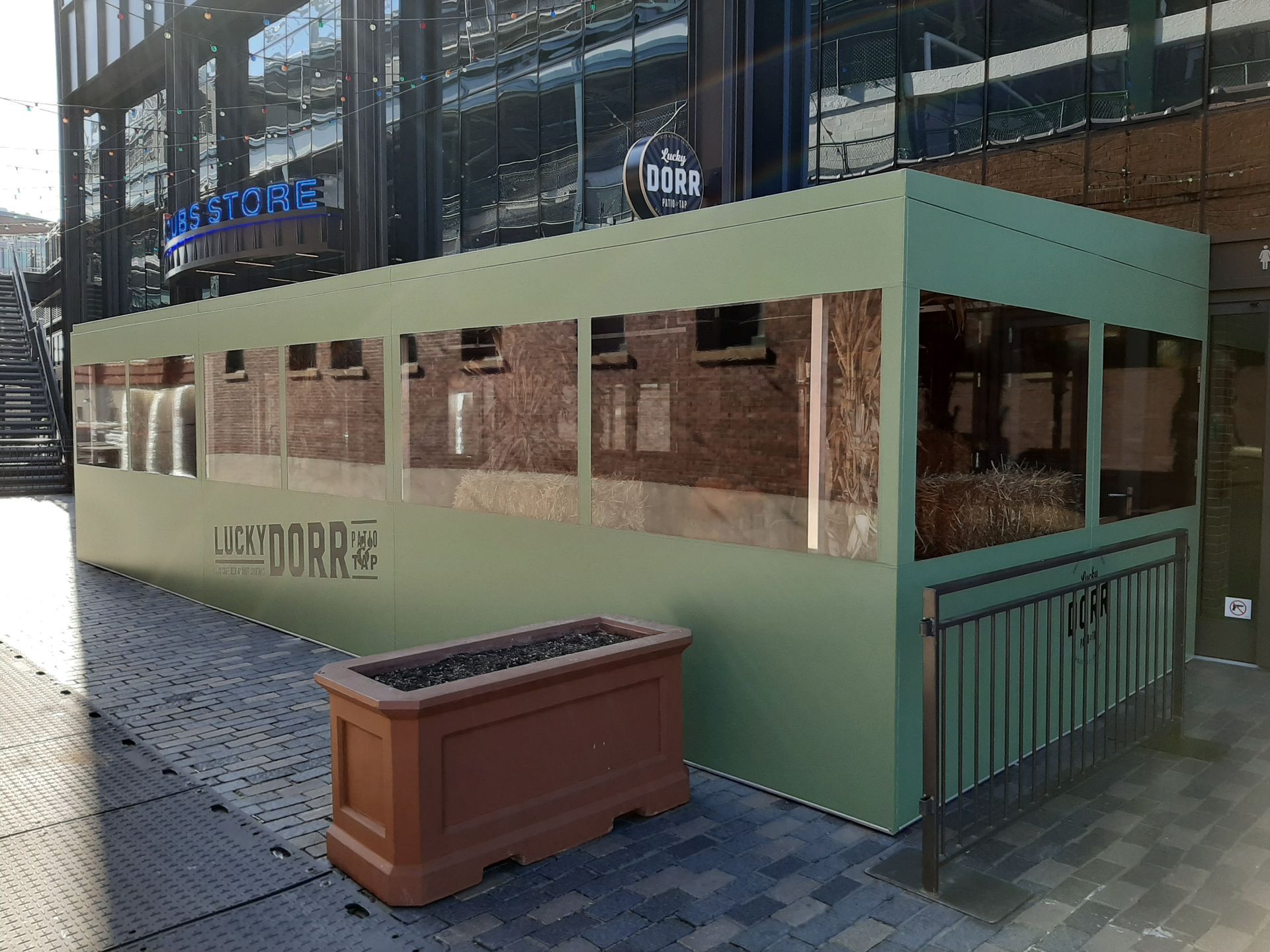 A green building with a planter in front of it