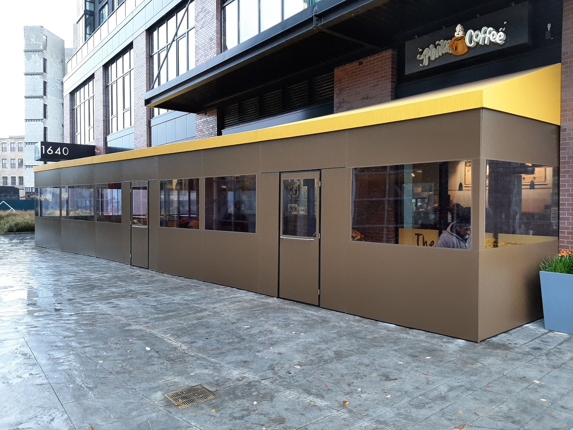 A building with a yellow awning and a sign that says coffee