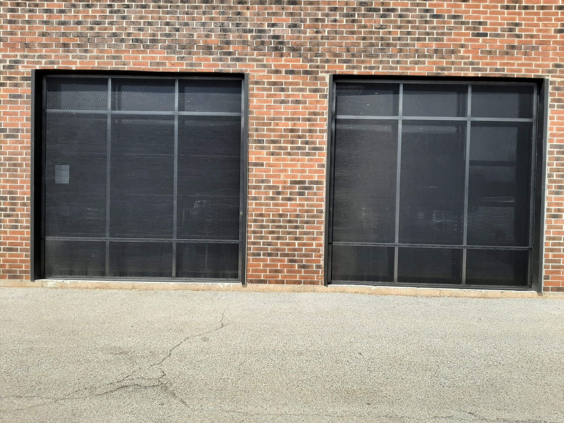 A brick building with two screened in garage doors