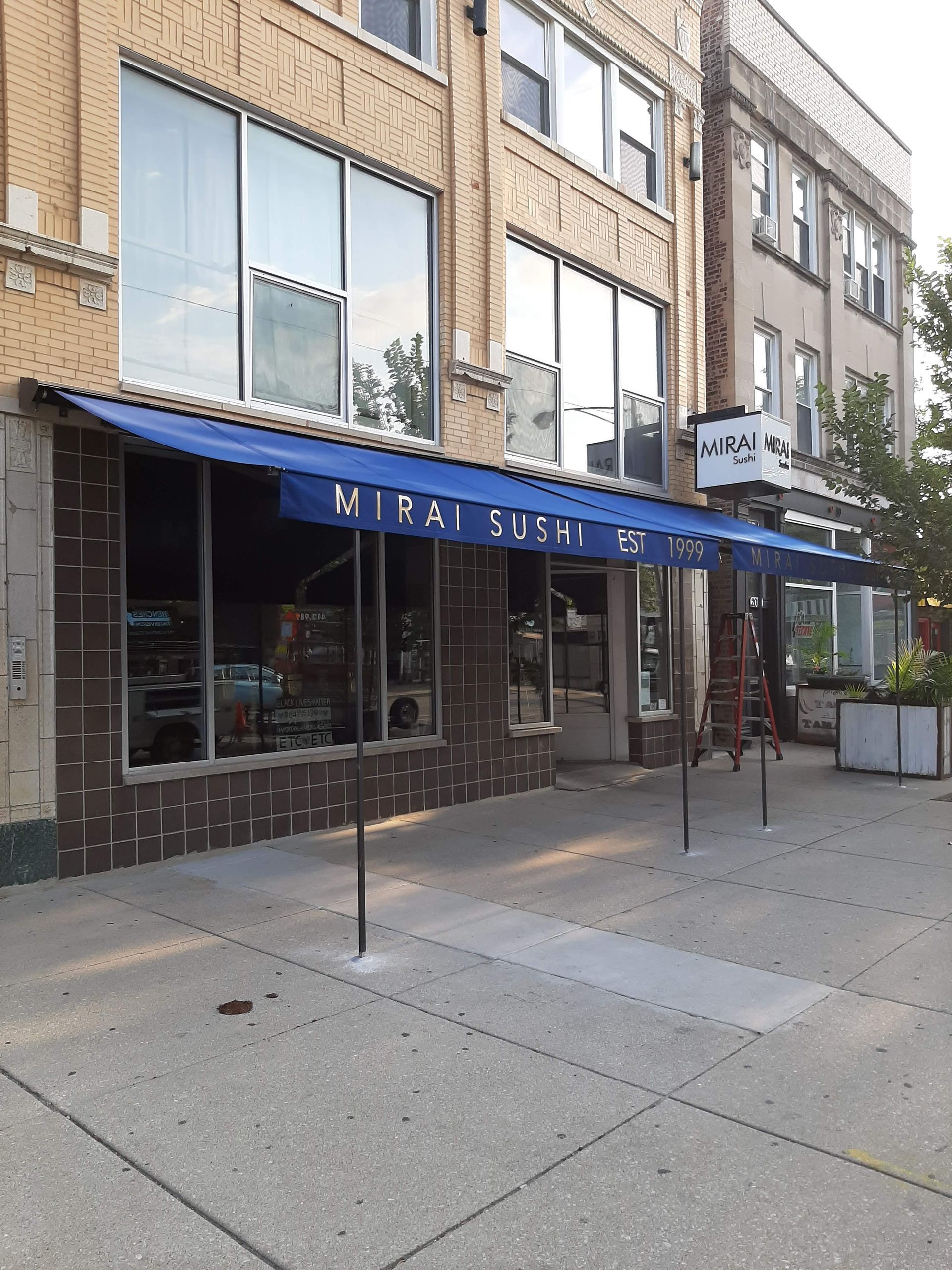 A building with a blue awning that says mirai