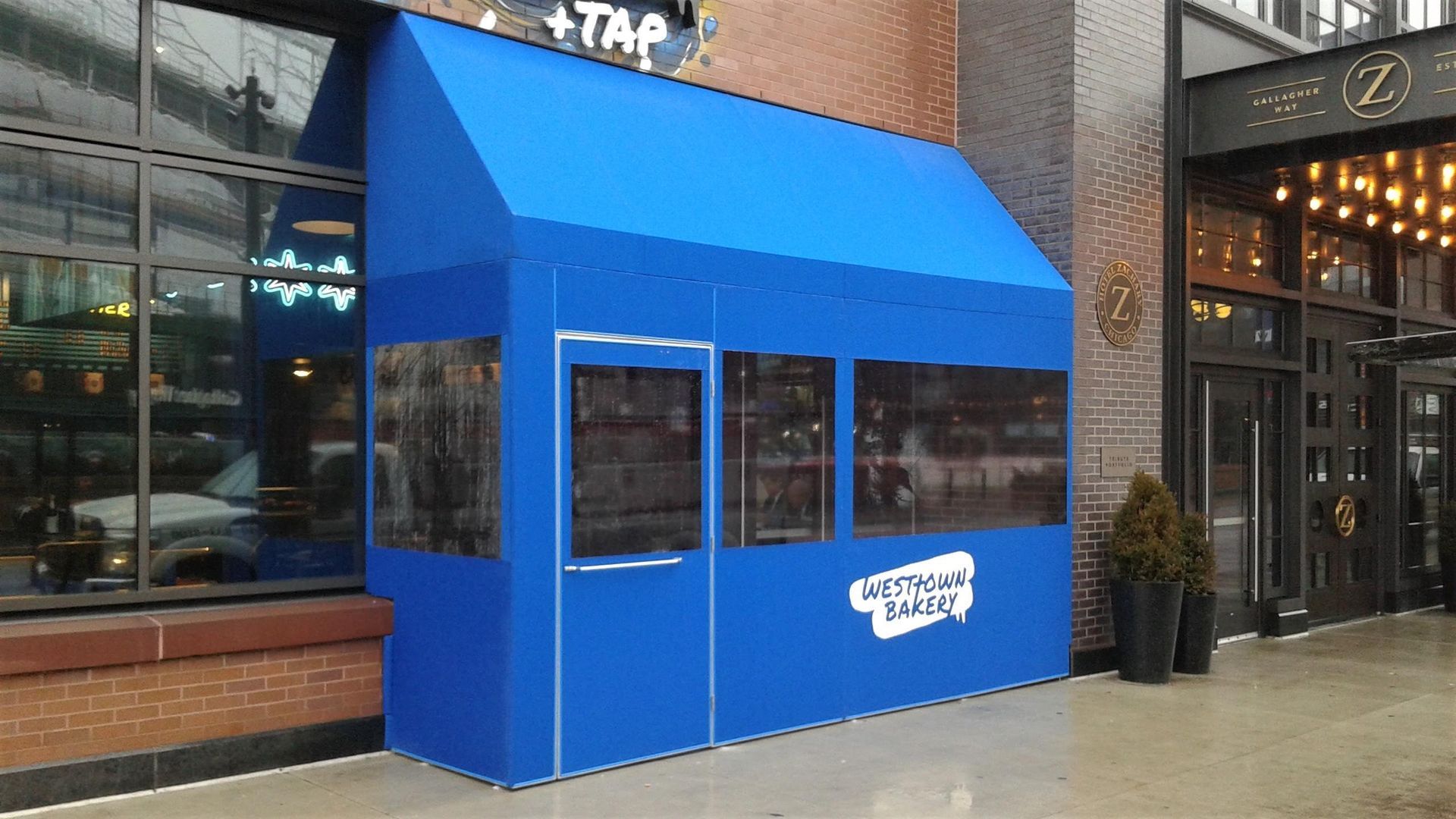 A blue awning is on the side of a building.
