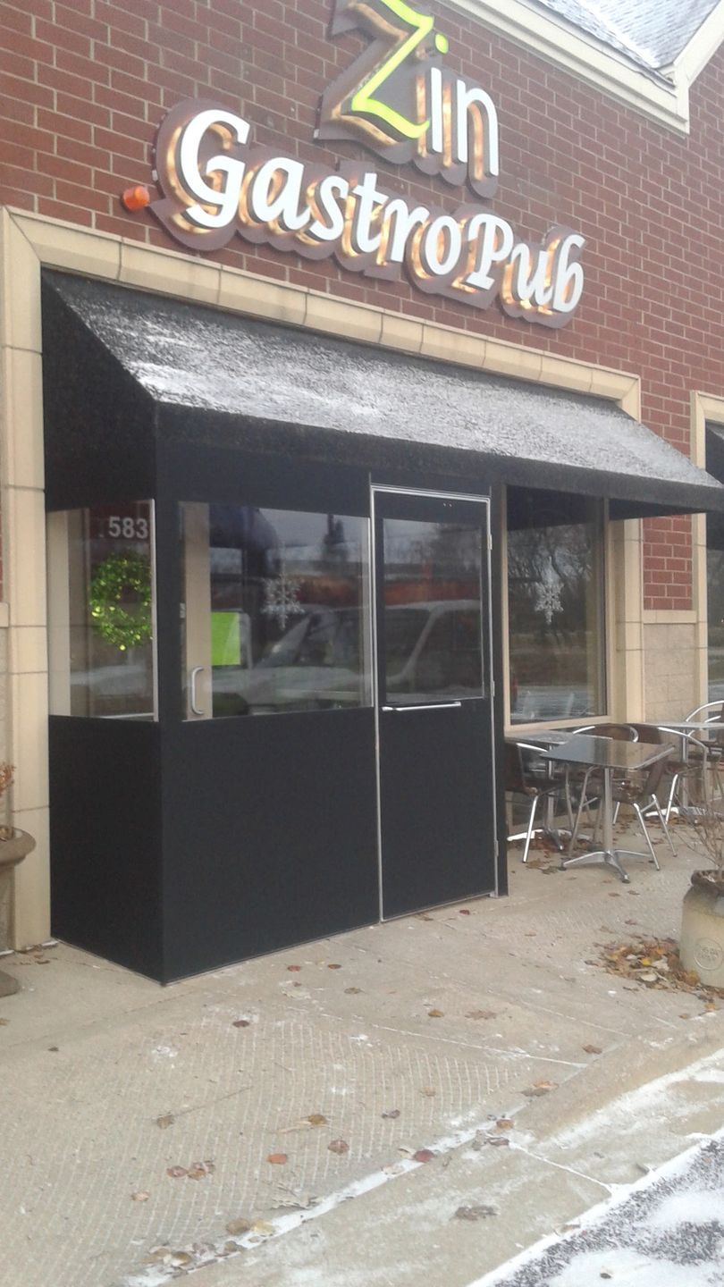 A restaurant with a black awning and a sign that says zin gastropub
