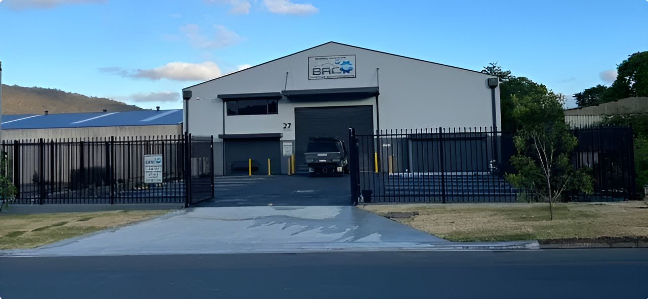 A Car is Parked in Front of a Large Building — Bowral Auto Care In Mittagong, NSW